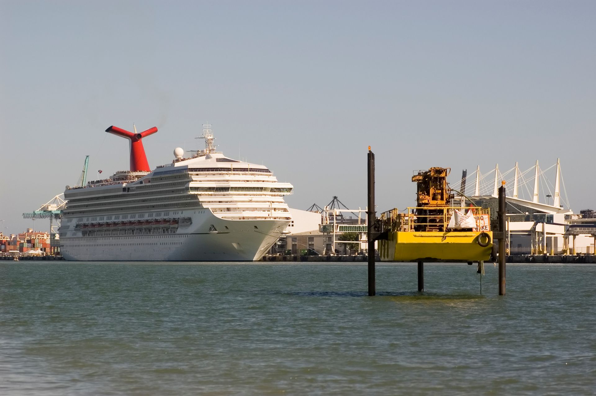 A large cruise ship is docked in a harbor