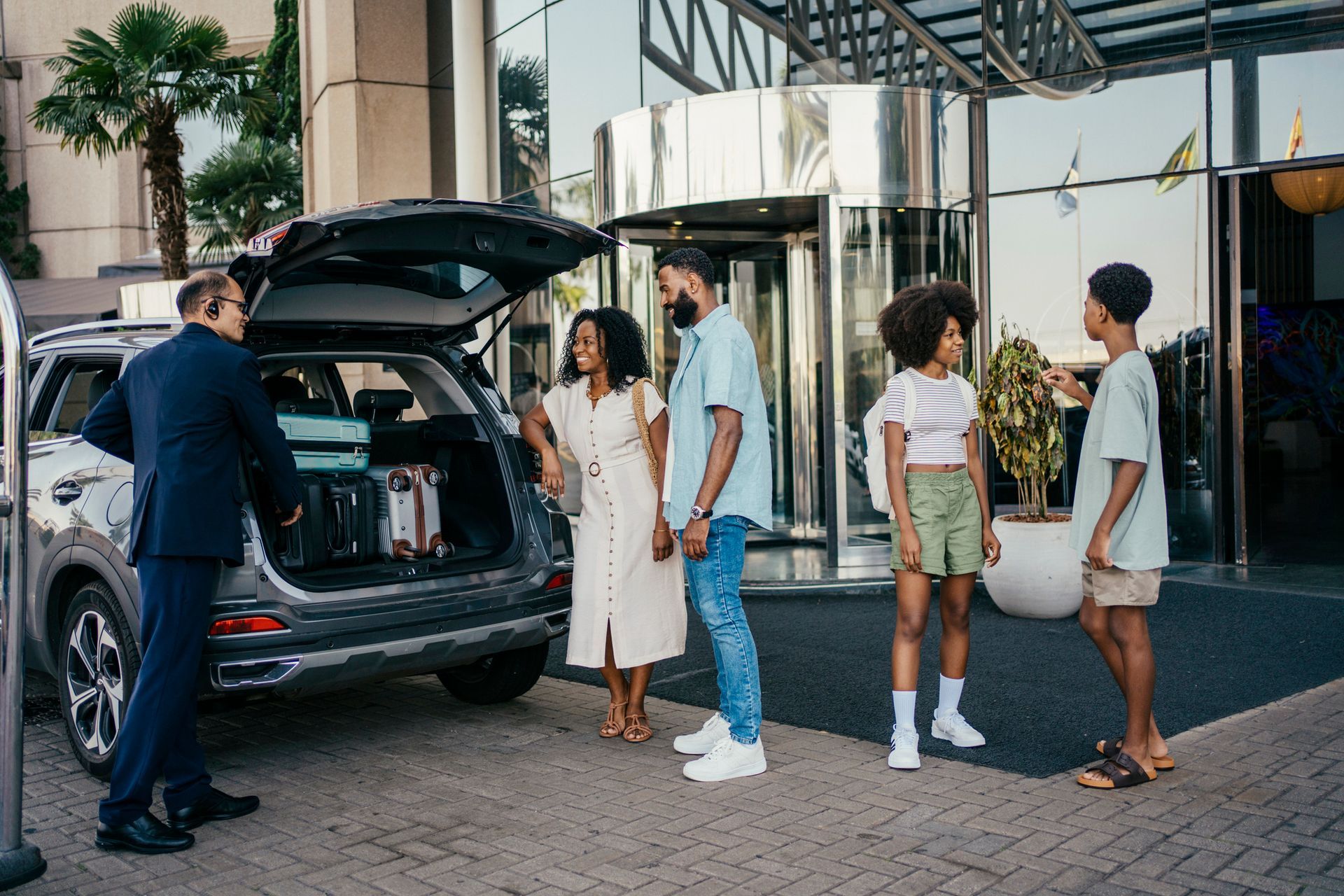 A man is loading luggage into the back of a car.