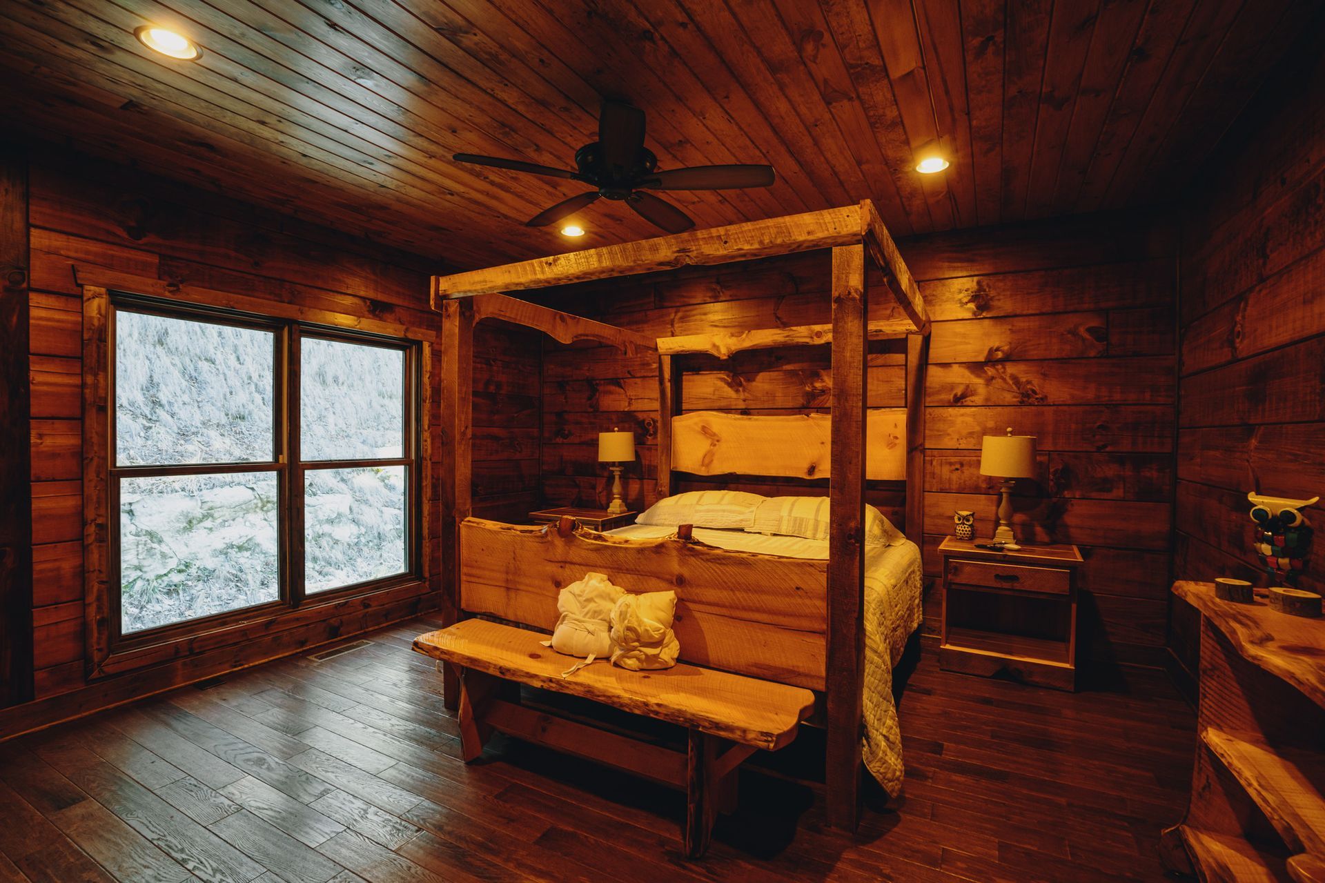 a bedroom in a log cabin with a canopy bed and a bench .
