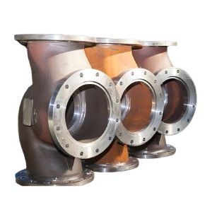 Tres accesorios de tubería industrial con bridas, uno al lado del otro.