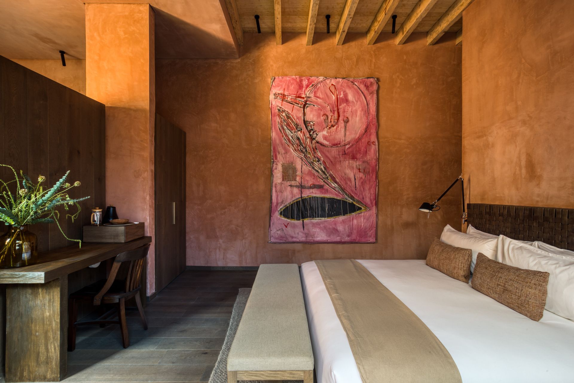 Un dormitorio con un cuadro grande en la pared encima de la cama.