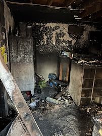 Interior room heavily damaged by fire; charred walls and debris on the floor.