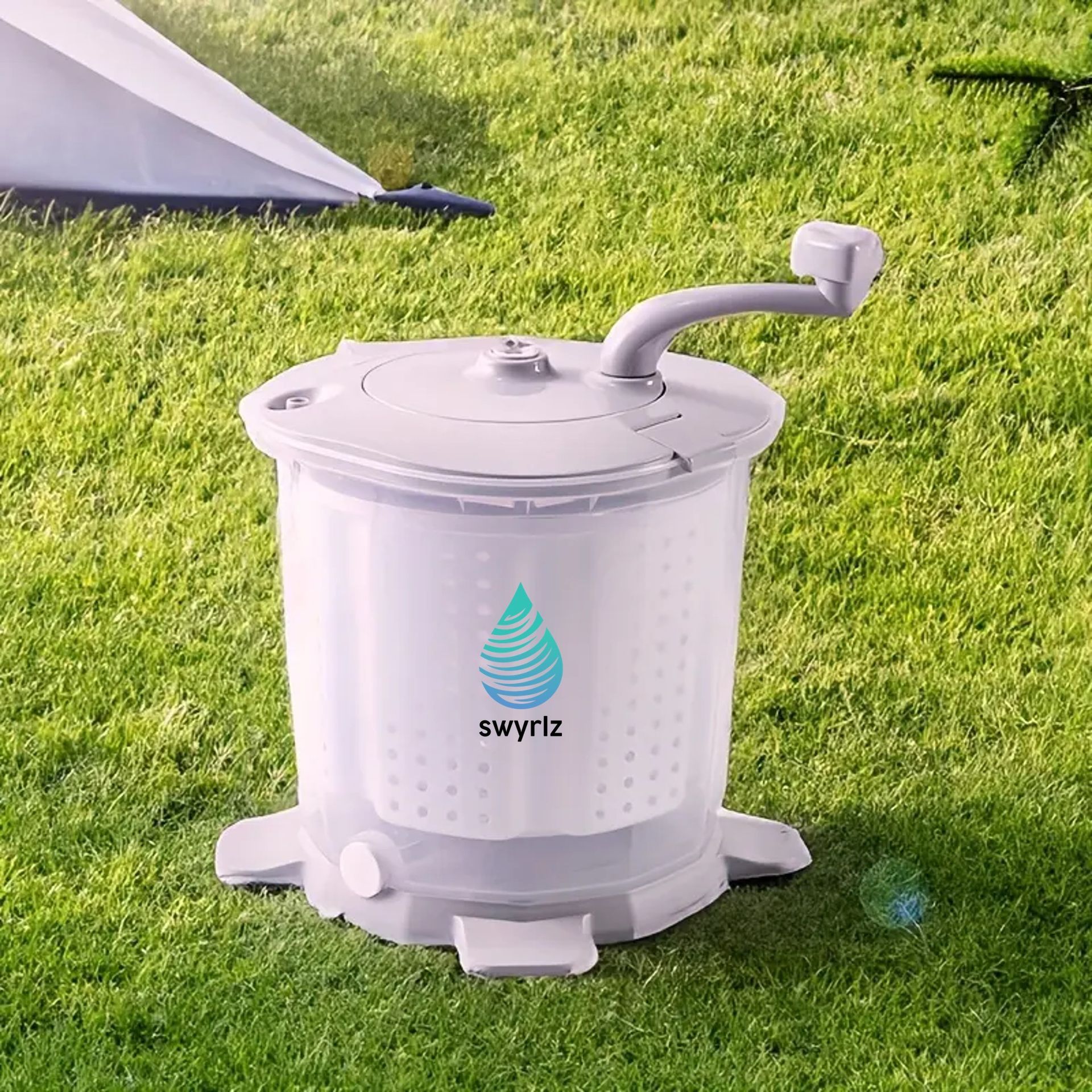 A manual washing machine with a handle in a grassy outdoor setting.