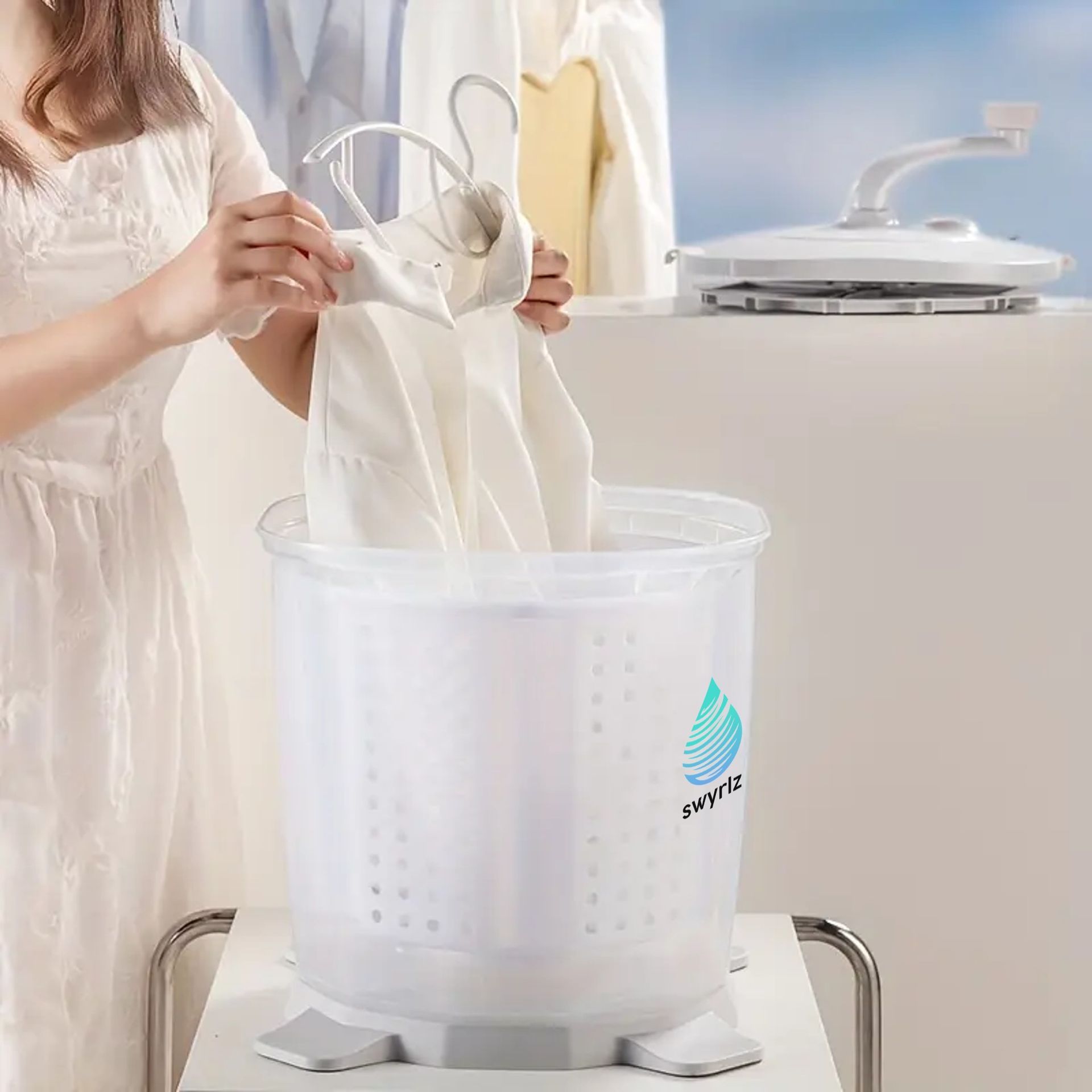Woman loading a white garment into a small, portable washing machine on a countertop.