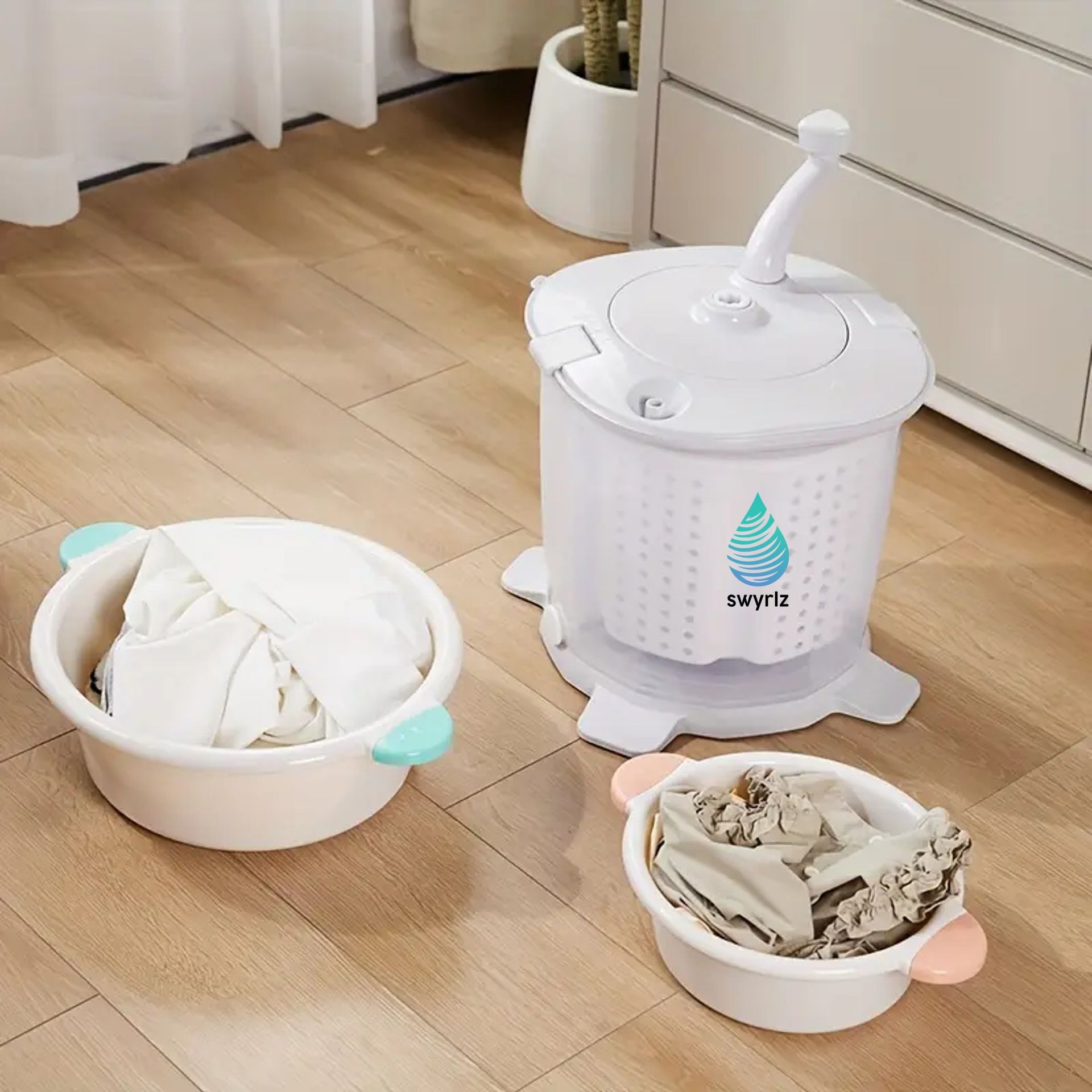A white portable washing machine with two basins of clothes on a wood floor.