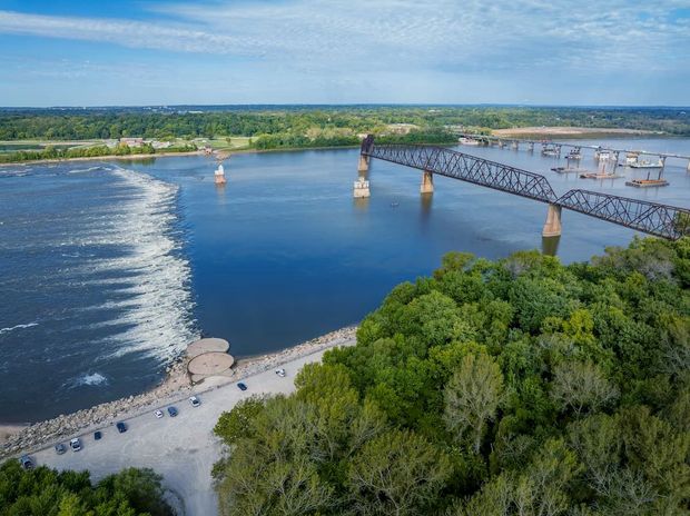 an aerial view of a bridge over the mississippi river surrounded by trees .