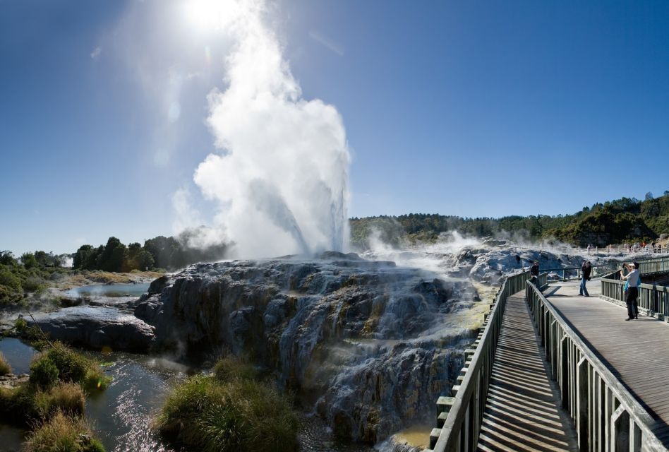 A bridge leading to a waterfall with smoke coming out of it
