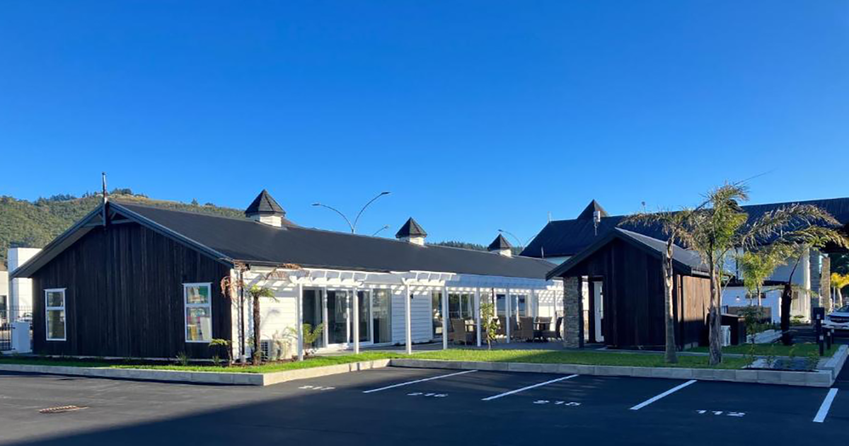 A large building with a lot of windows and a parking lot in front of it.