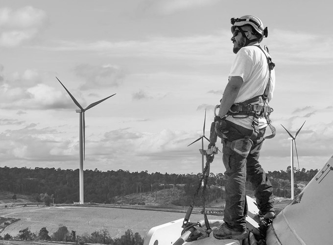 Technician in safety harness on a wind turbine after GWO training in Belfast