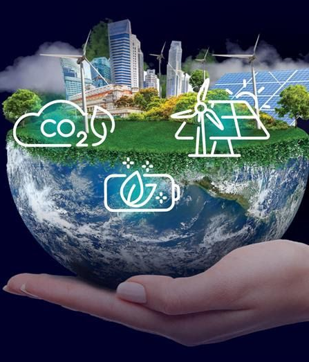 Hand holding a half-globe with a green landscape of eco-friendly elements: wind turbines, solar panels, and buildings.