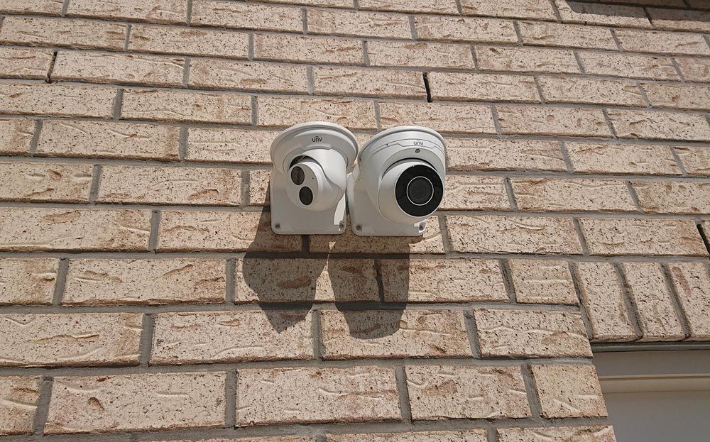Two Security Cameras Mounted Side  By Side On A Brick Wall — Ontime Locksmiths & Security In Mullumbimby, NSW