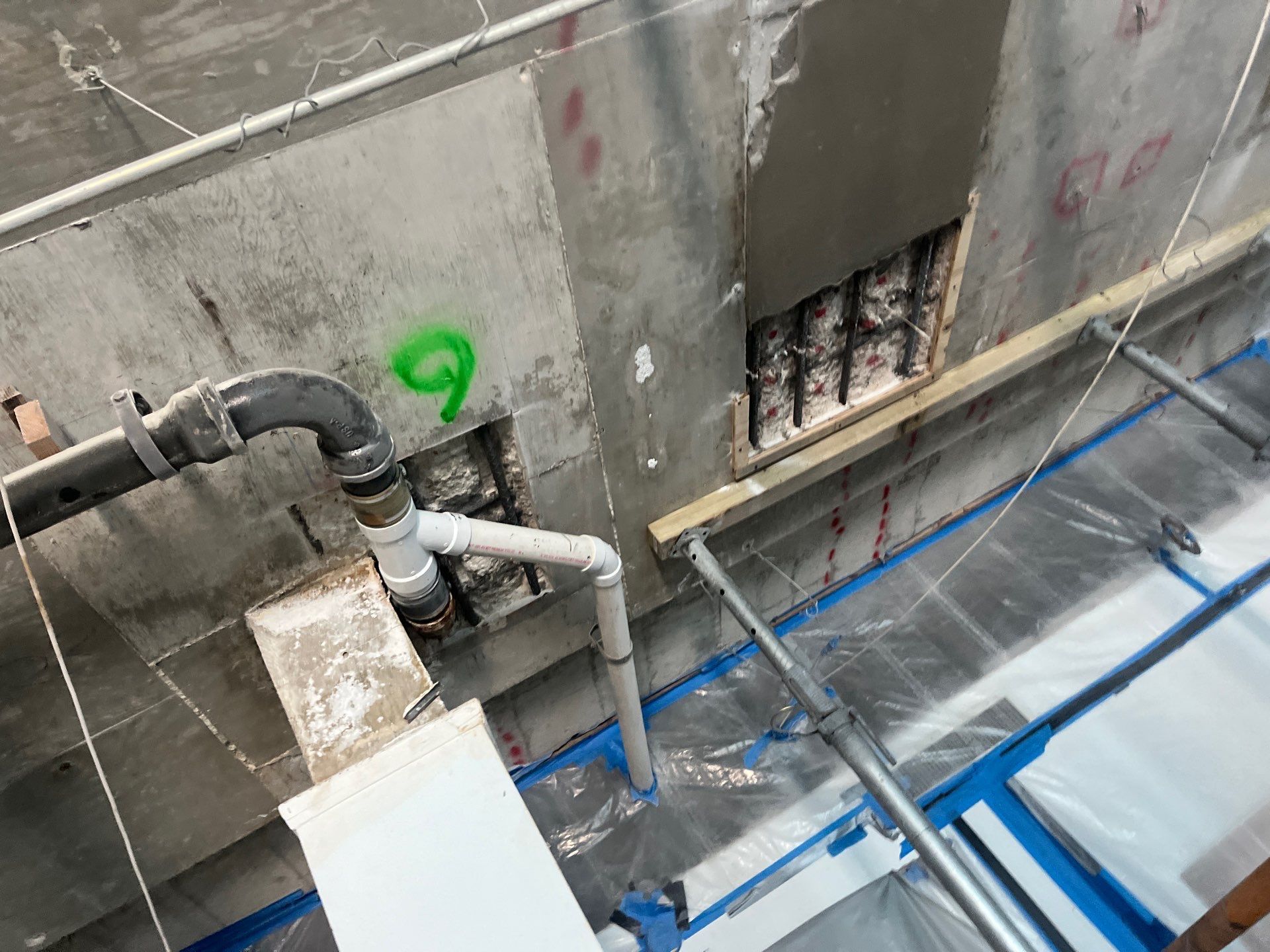 A pipe is being installed in a hole in a wall.