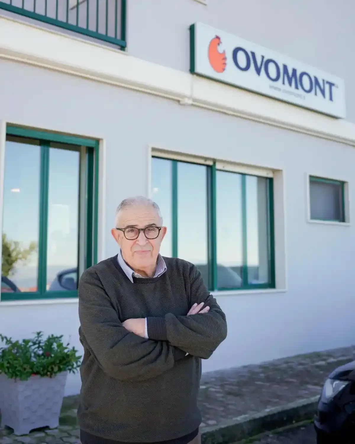 Mano di una persona che prende un uovo marrone da una scatola di cartone piena di altre uova marroni.