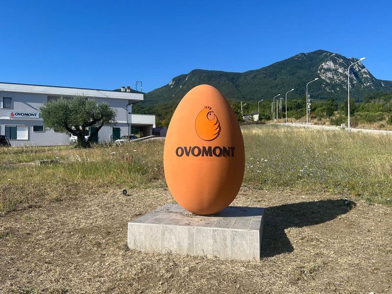 Una statua arancione a forma di uovo con la scritta