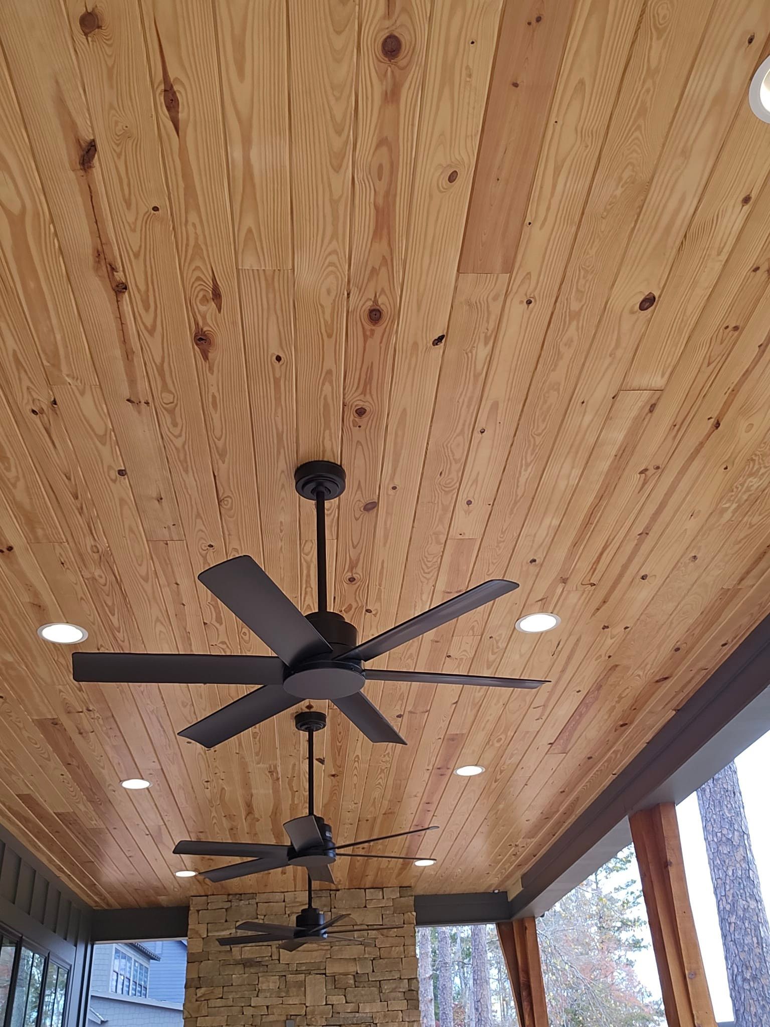 Wood plank ceiling with dark ceiling fans and recessed lights.