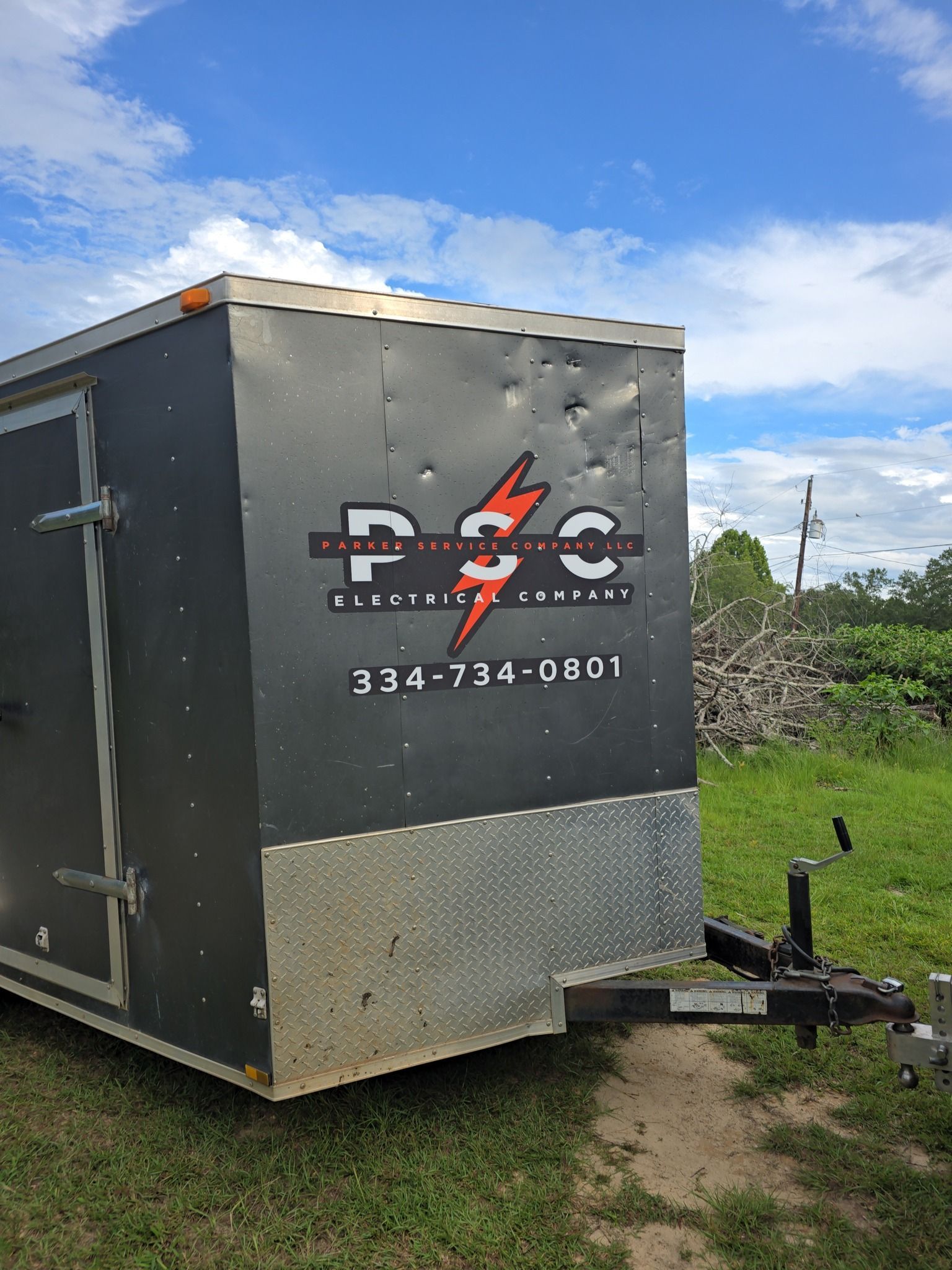 Dark gray trailer with a logo for P2C, phone number 374-734-0801, on the side.
