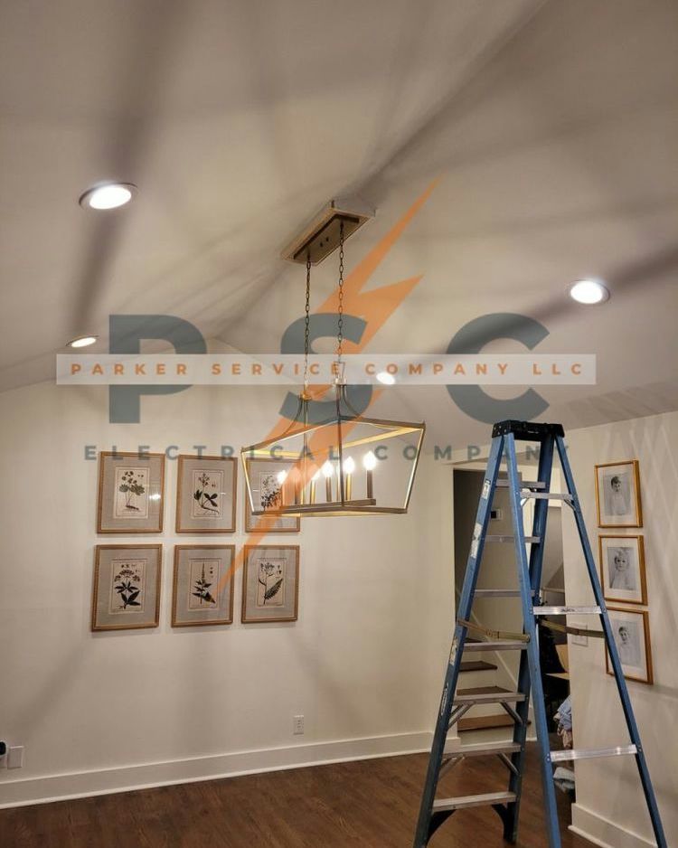 Ladder next to a light fixture installation in a room with artwork and recessed lighting.