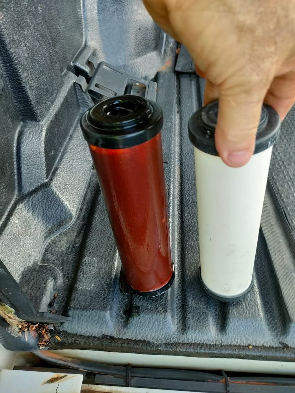 A Person Is Holding Two Different Types Of Filters In Their Hand — Cairns Clear Water Company In Cairns, QLD