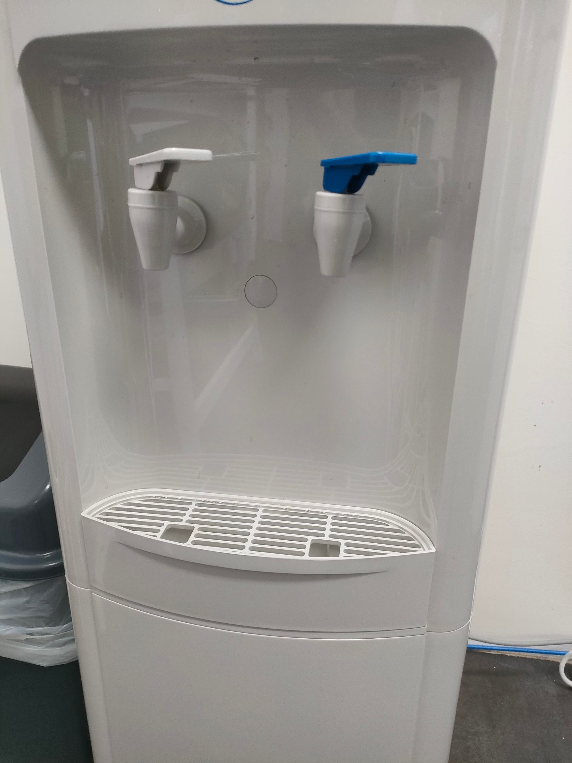 A Person Is Pouring Water Into A Cup From A Water Dispenser — Cairns Clear Water Company In Westcourt, QLD