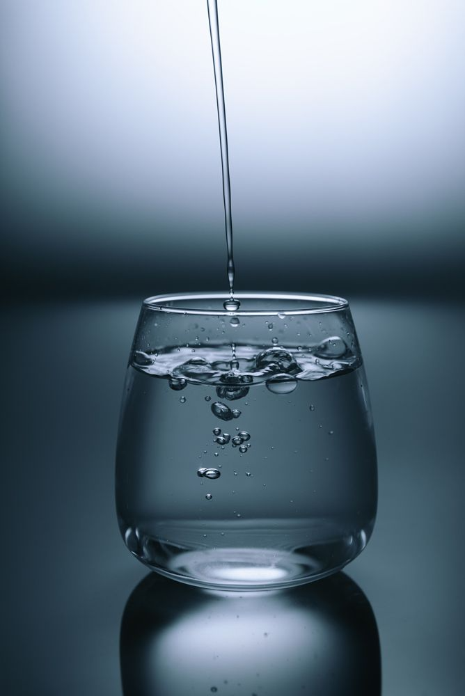 Water Is Being Poured Into A Glass On A Table — Cairns Clear Water Company In Westcourt, QLD
