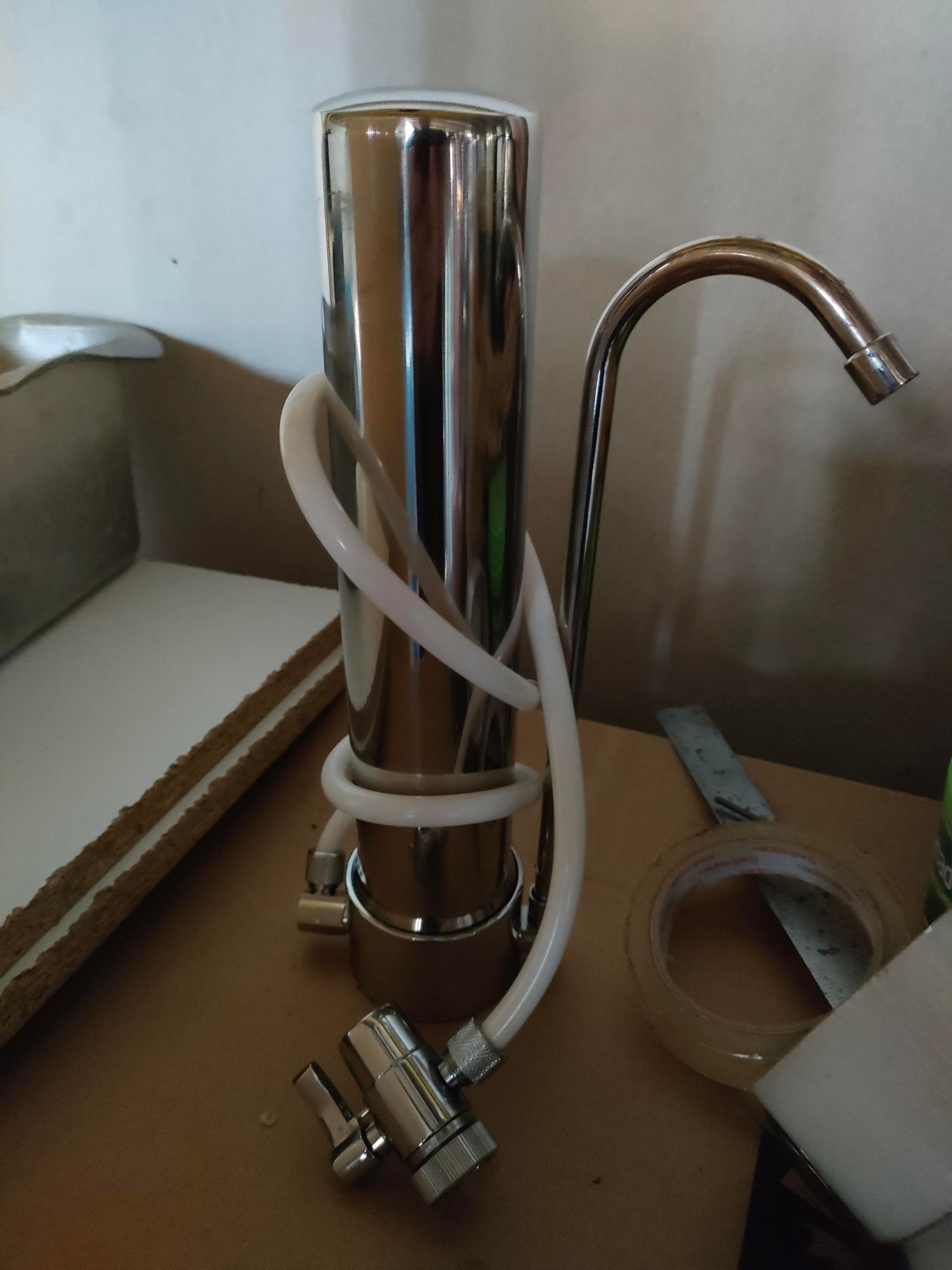 A Water Filter Is Sitting On A Counter Next To A Tank — Cairns Clear Water Company In Westcourt, QLD