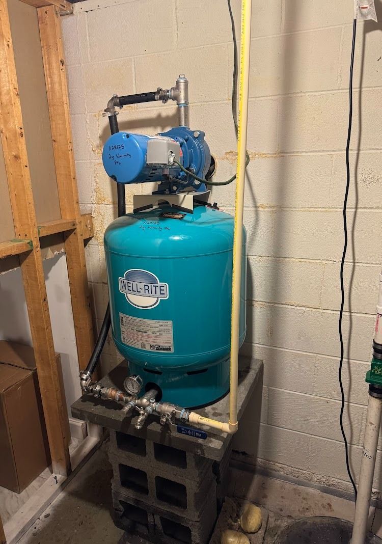 Blue water pump atop cinder block in a basement setting.