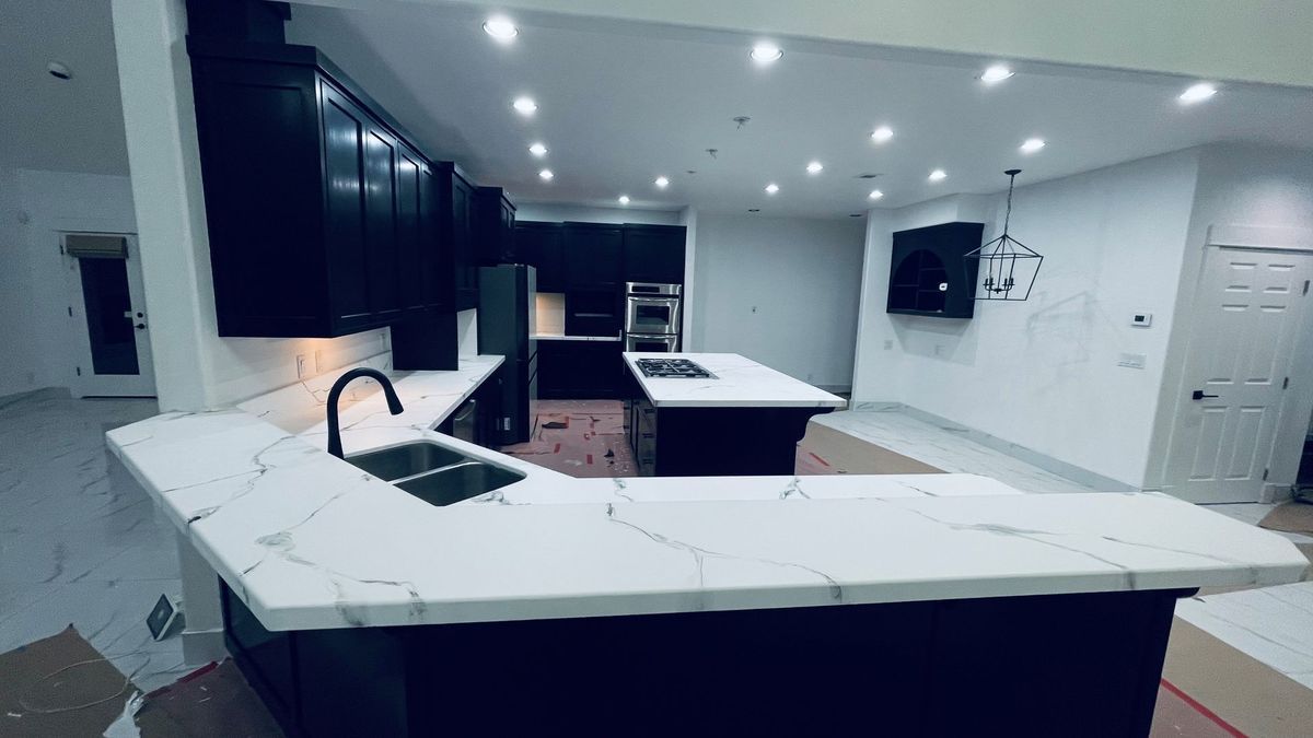 Elite Surface Coatings -Black kitchen cabinets with white countertops. Kitchen island in center.