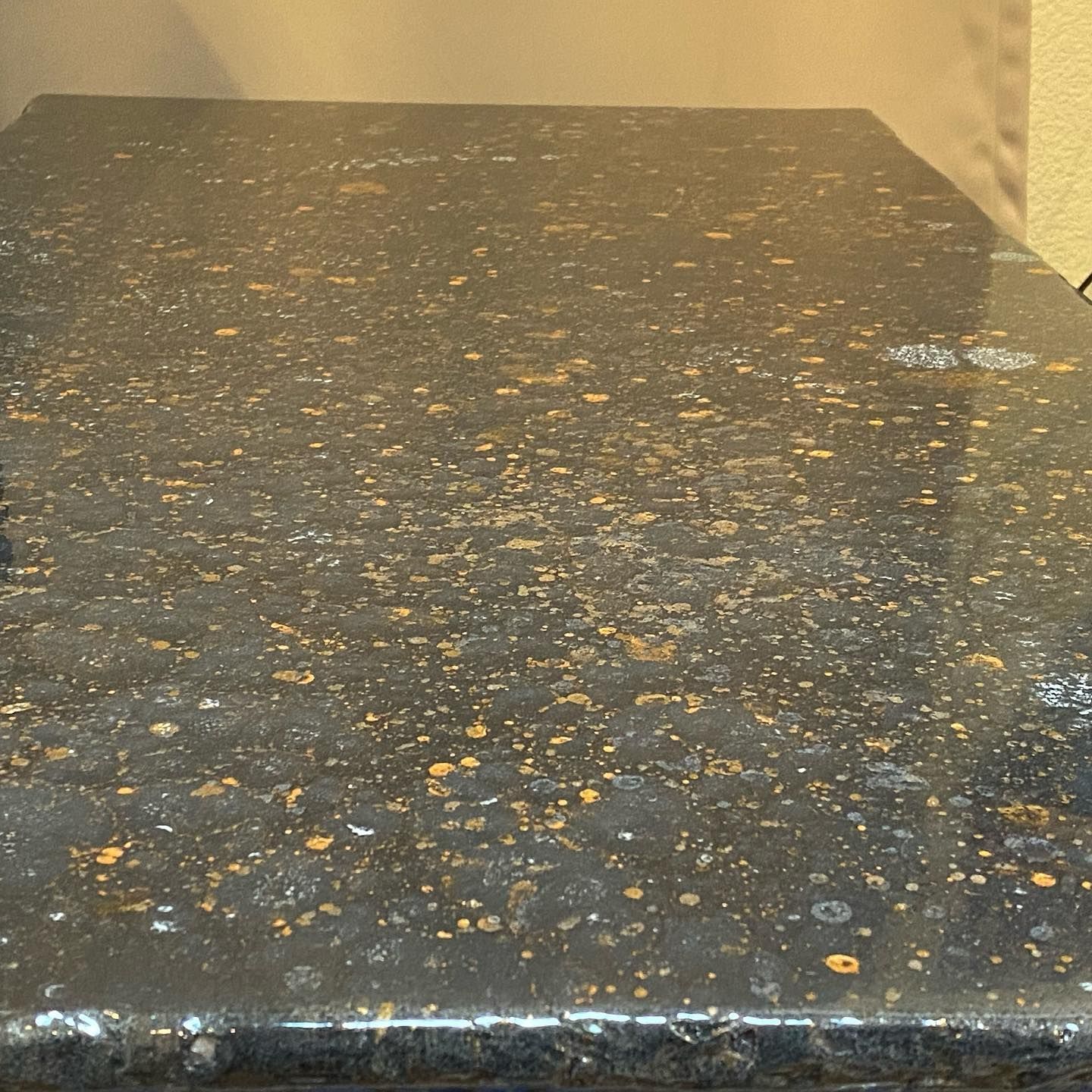 Elite Surface Coatings - Black and gold speckled countertop, reflecting light.