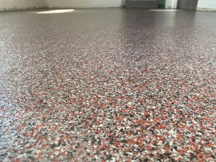 A close up of a multicolored concrete floor in a garage.