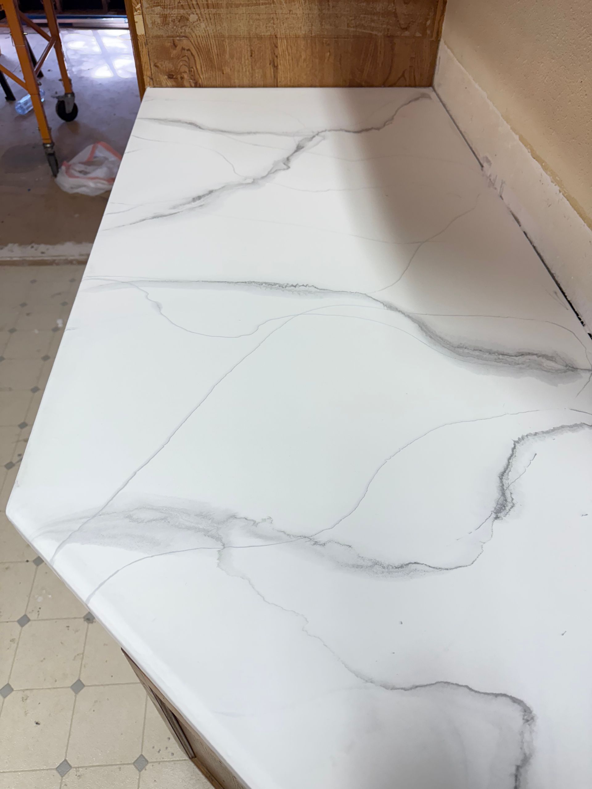 Elite Surface Coatings - White countertop with gray marbling; kitchen setting.