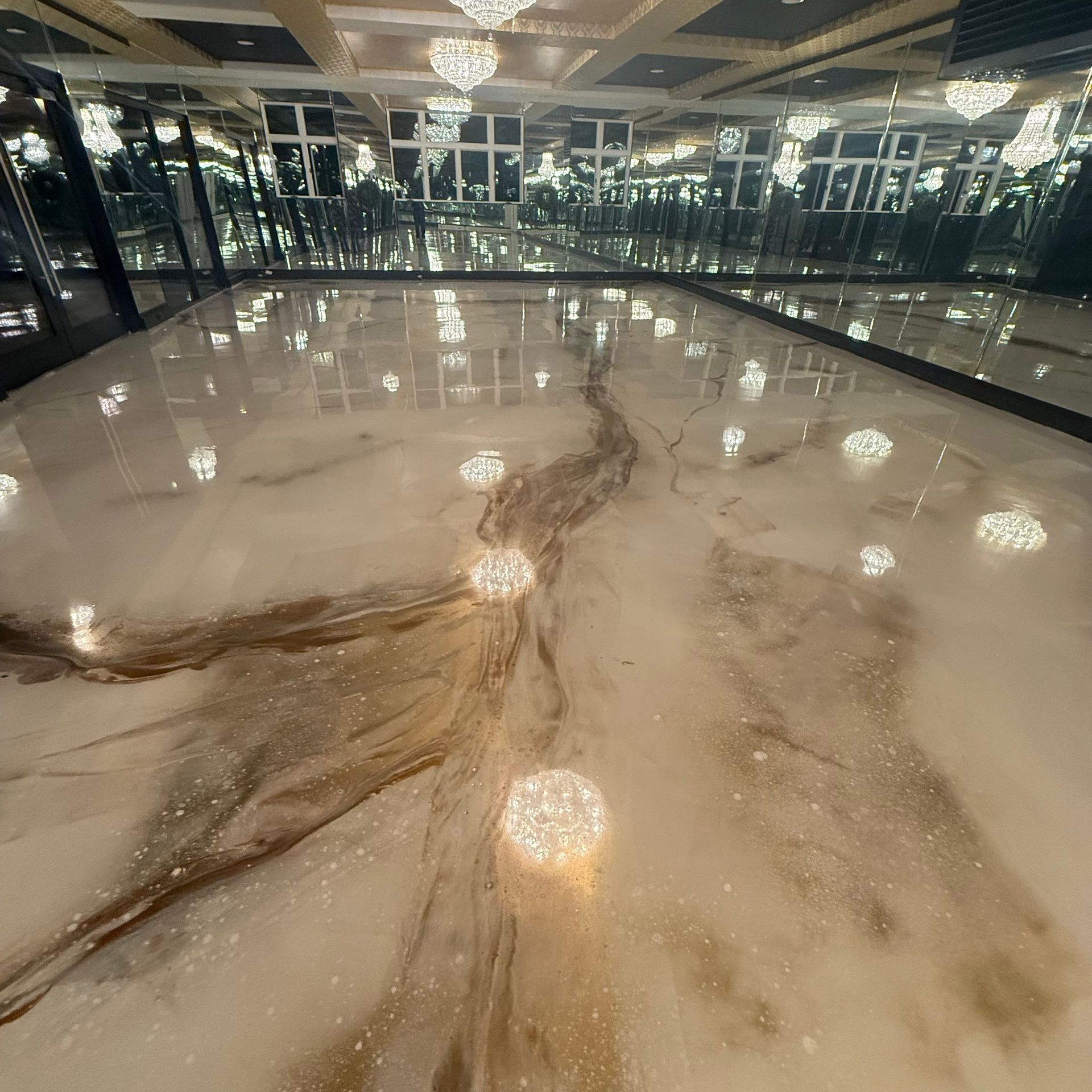 Elite Surface Coatings - Glossy floor with marble effect, gold streaks, and decorative lights, reflecting a mirrored ceiling.