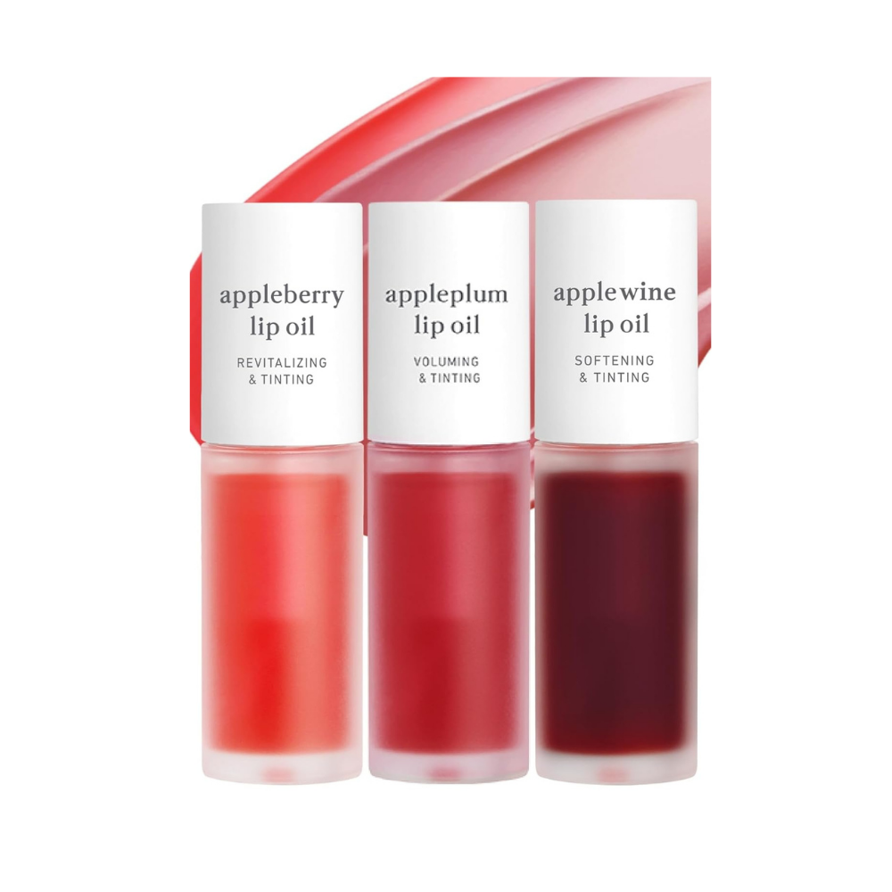 Three Apple lip oils in red, pink, and burgundy shades with matching gradient packaging.
