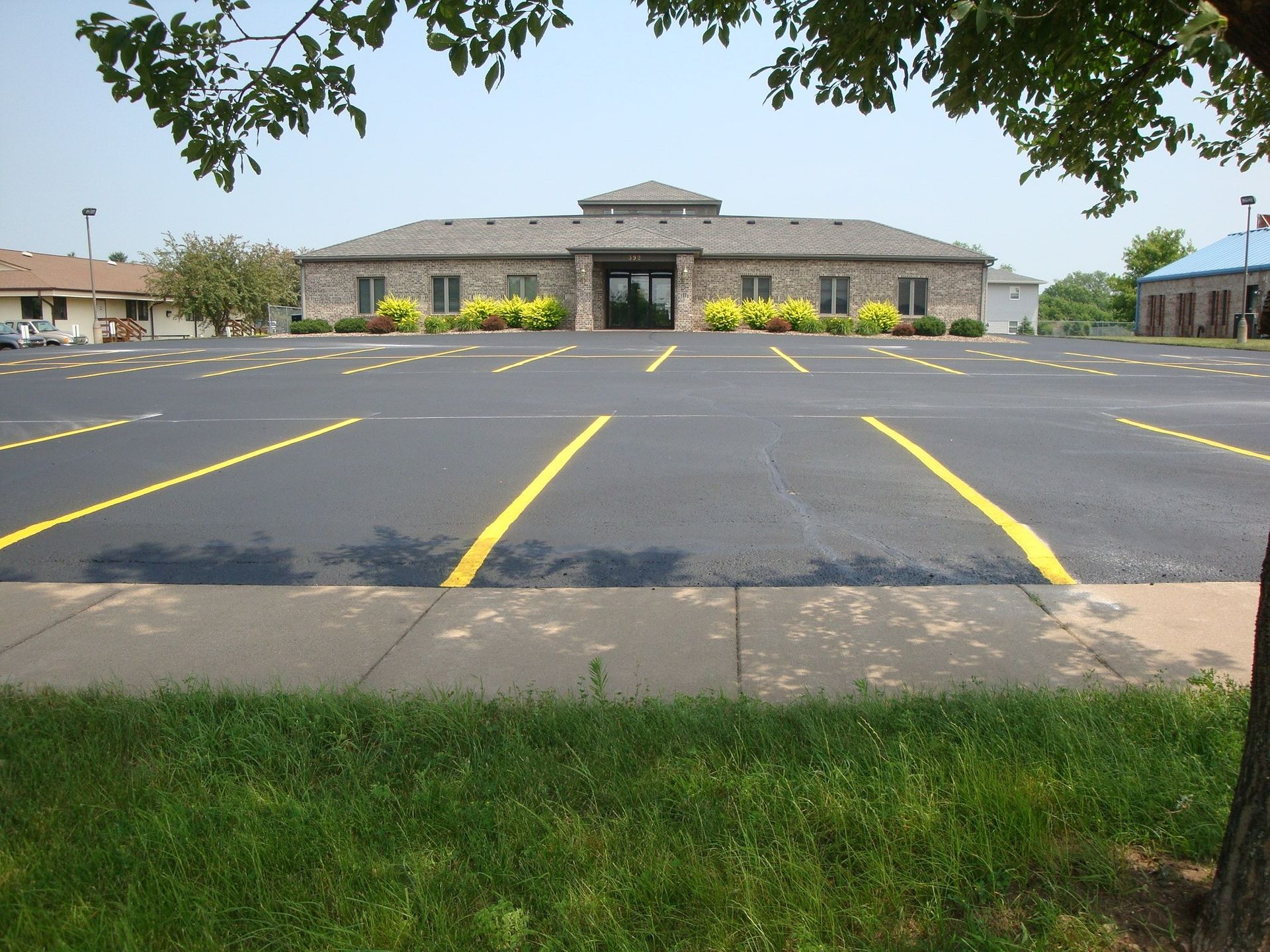 Large parking lot in front of a stone building with yellow parking lines.