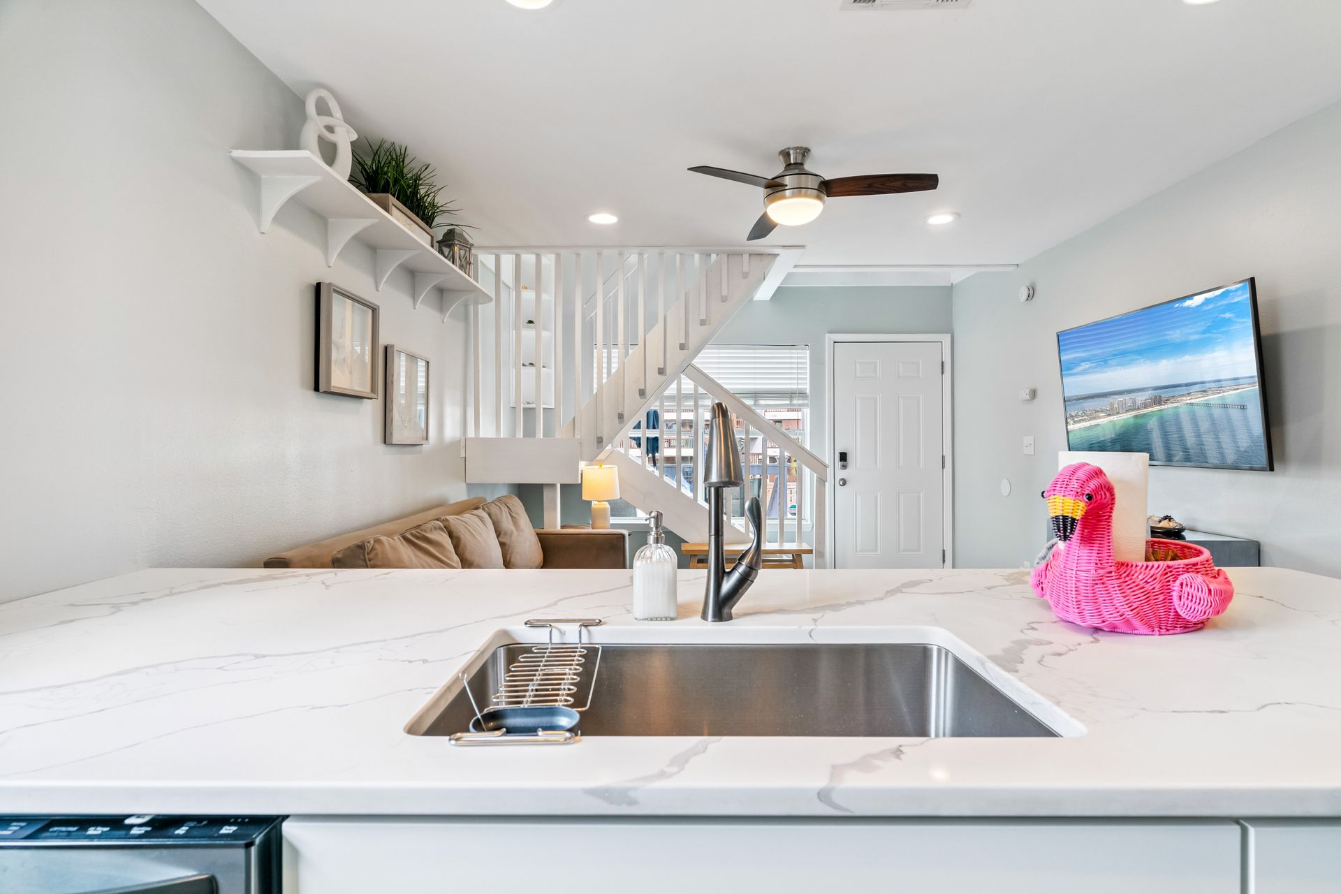 A kitchen with a sink and a flamingo float on the counter.
