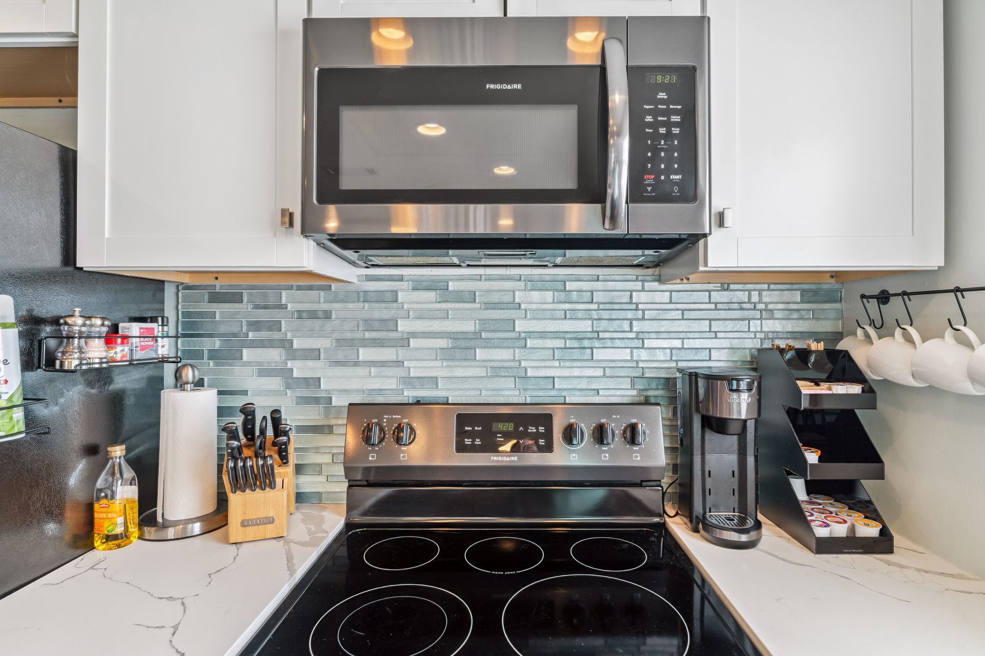 A kitchen with a stove , microwave , and coffee maker.