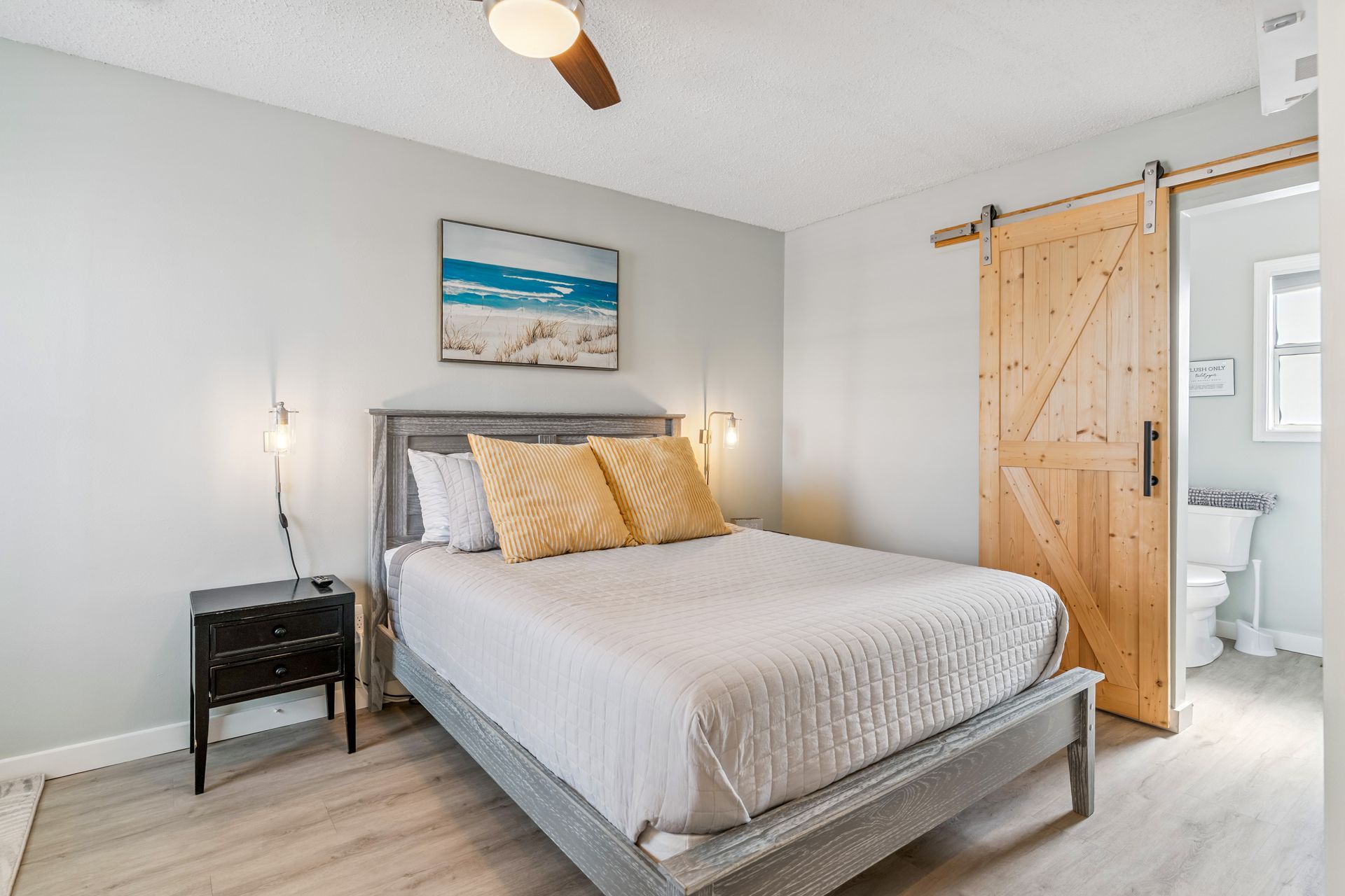 A bedroom with a king size bed and a sliding barn door.