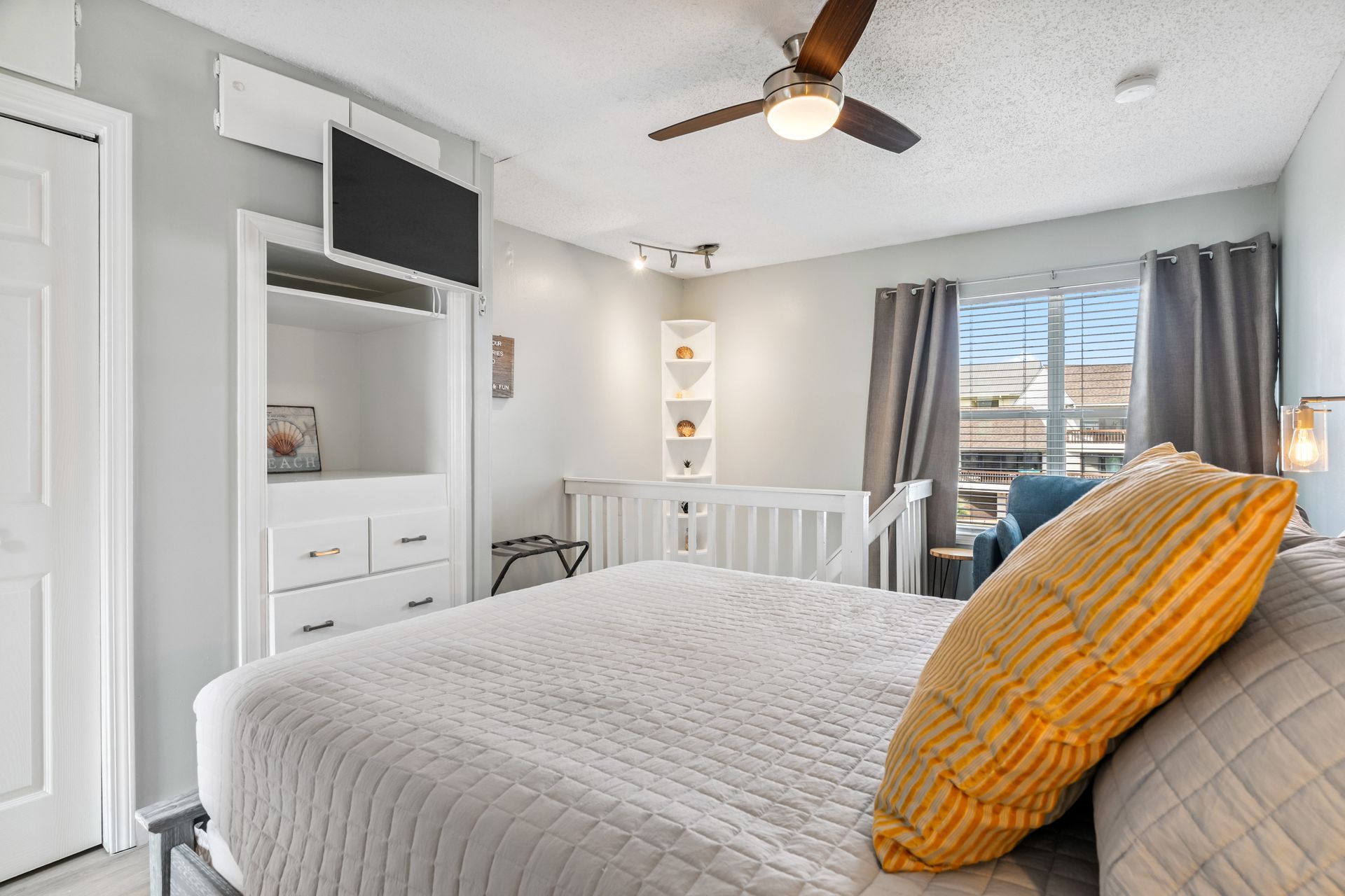 A bedroom with a king size bed , television , and ceiling fan.