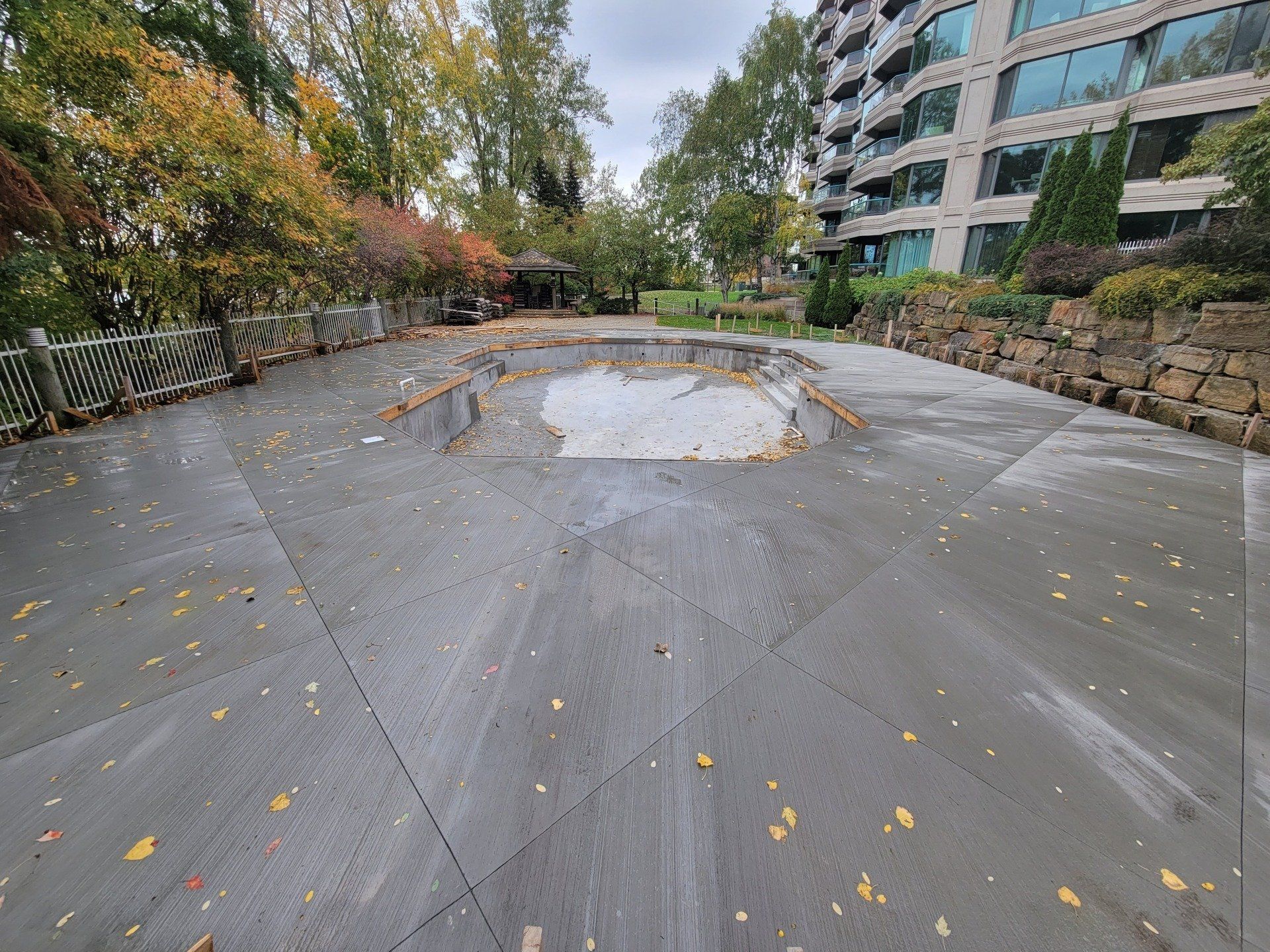 A concrete driveway with a large hole in the middle of it.