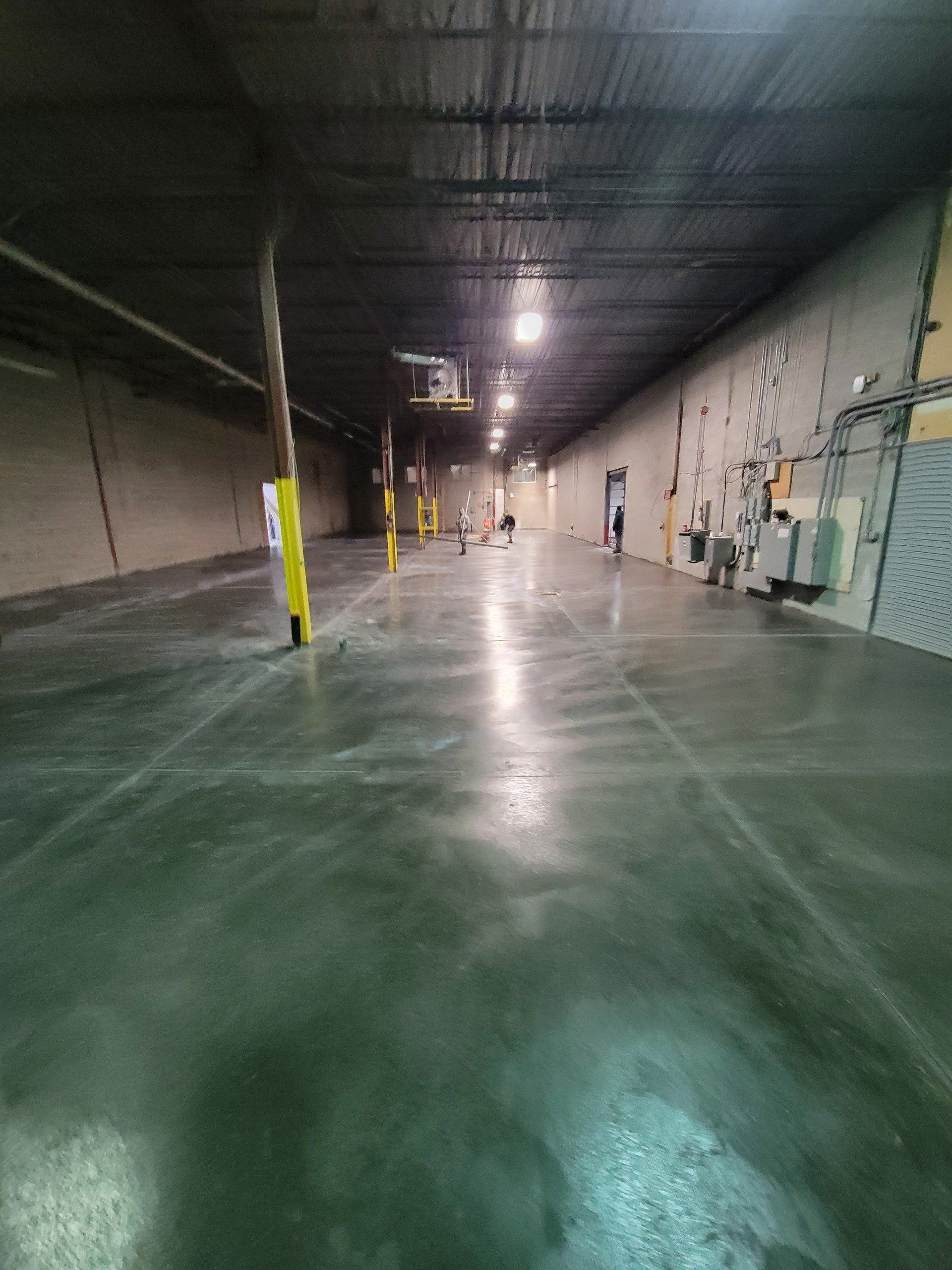 Un grand entrepôt avec un sol et des murs en béton.