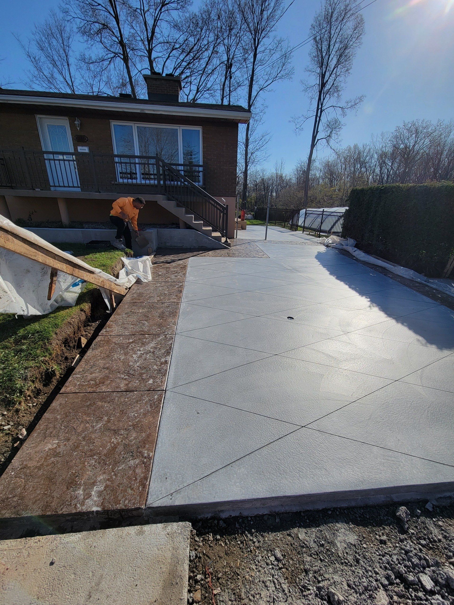 A concrete driveway is being built in front of a house.