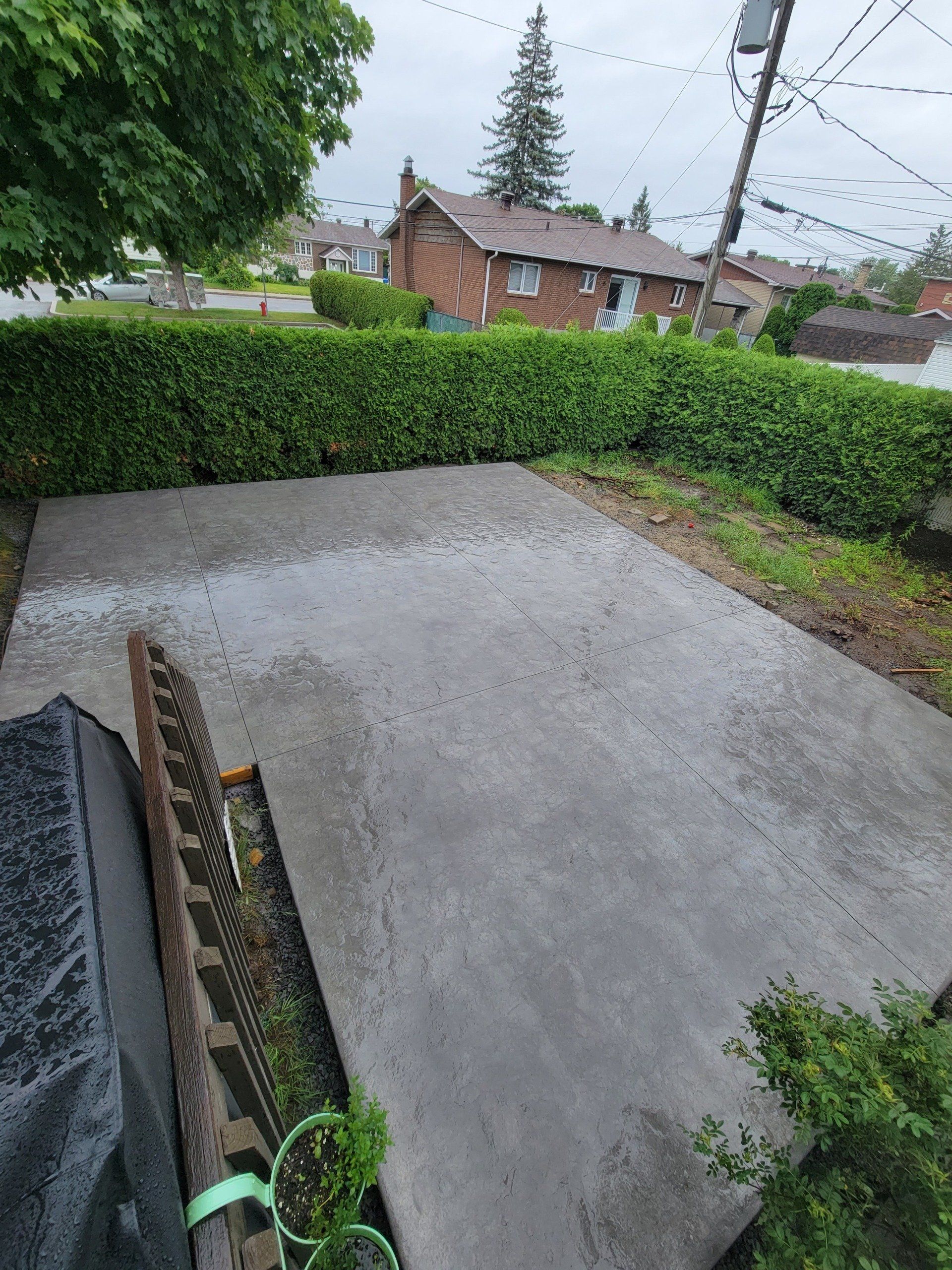 A concrete patio is being built in a backyard.