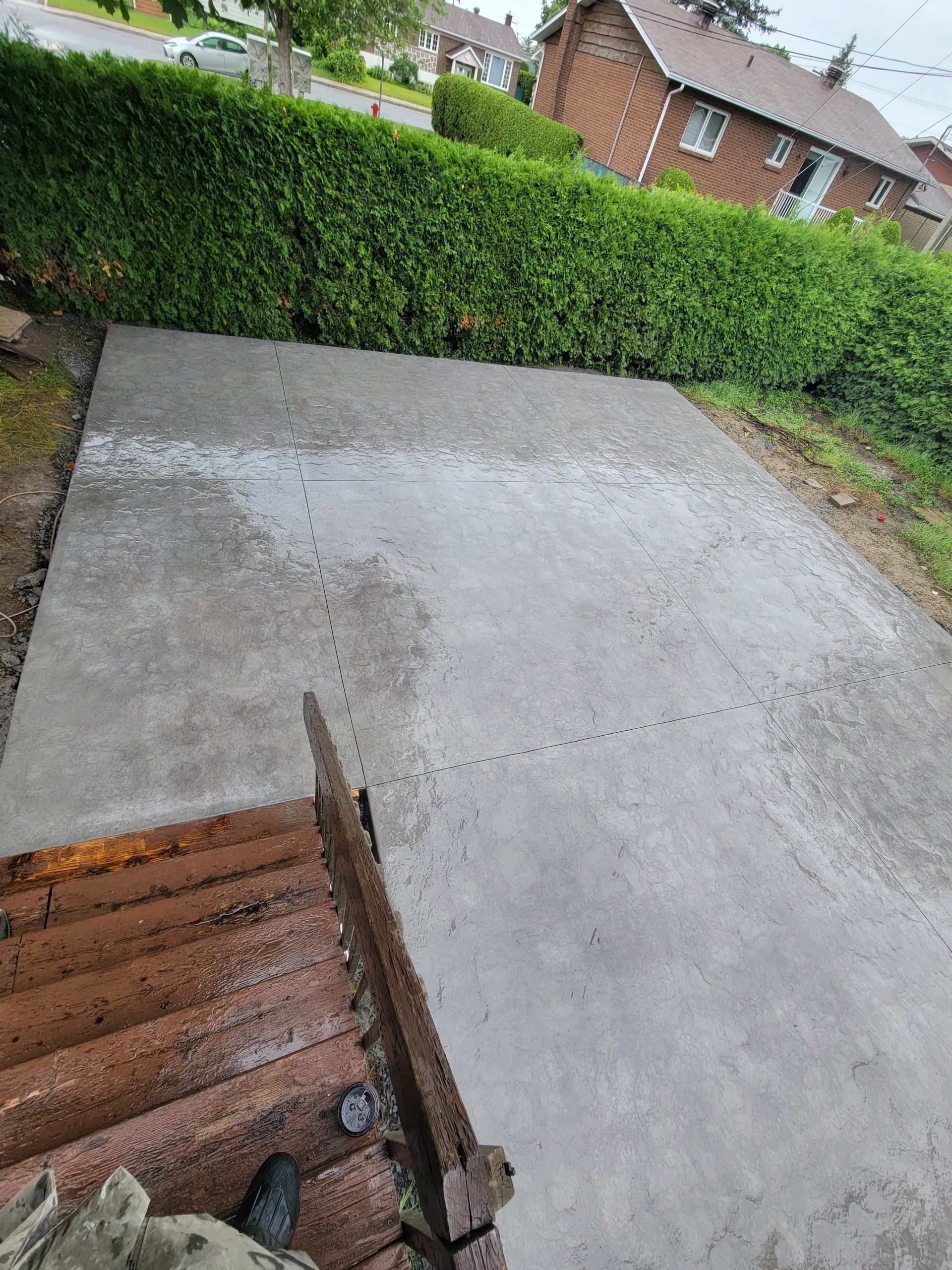 A concrete driveway is being built in front of a house.