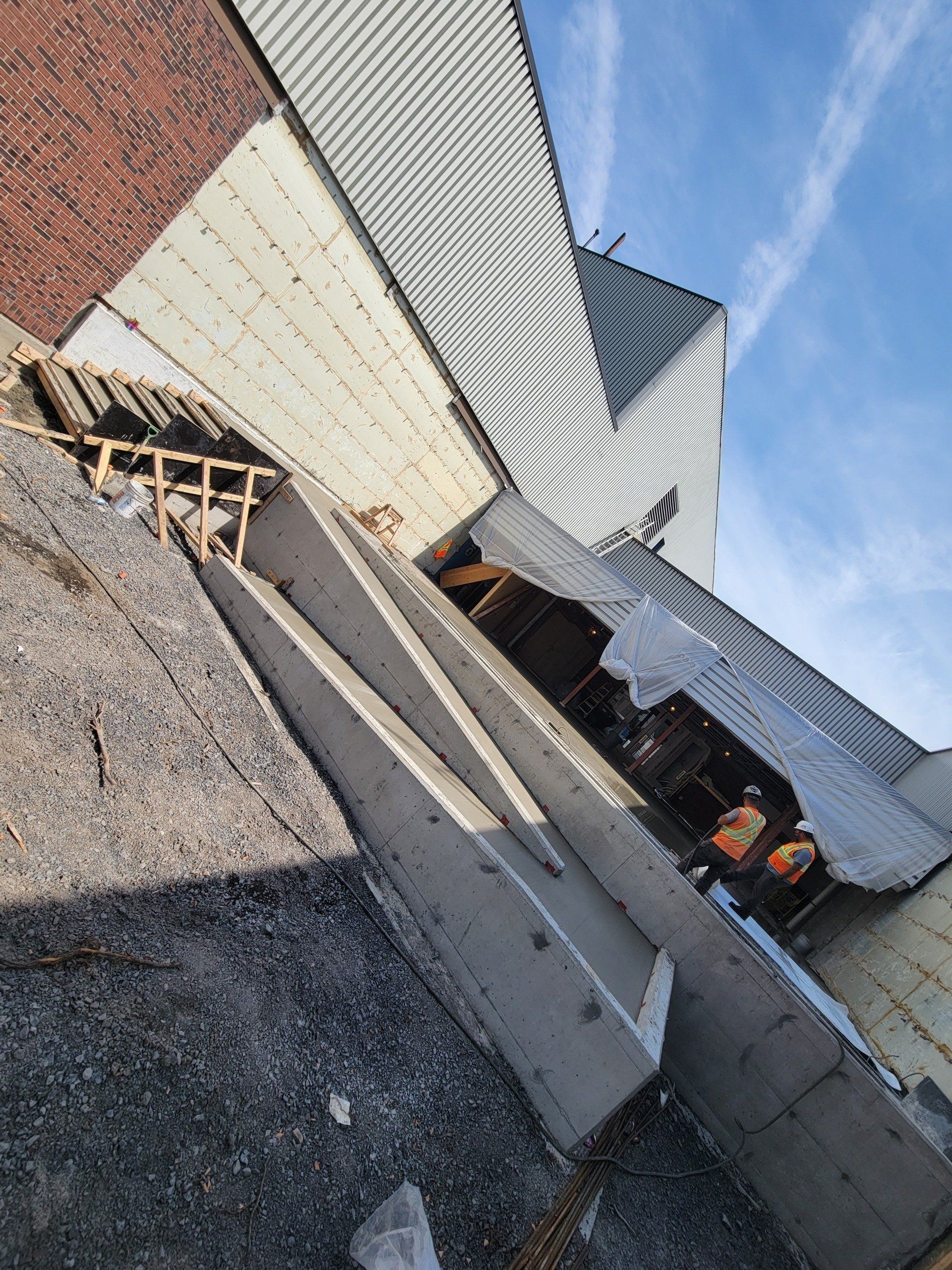 A group of construction workers are working on the side of a building.