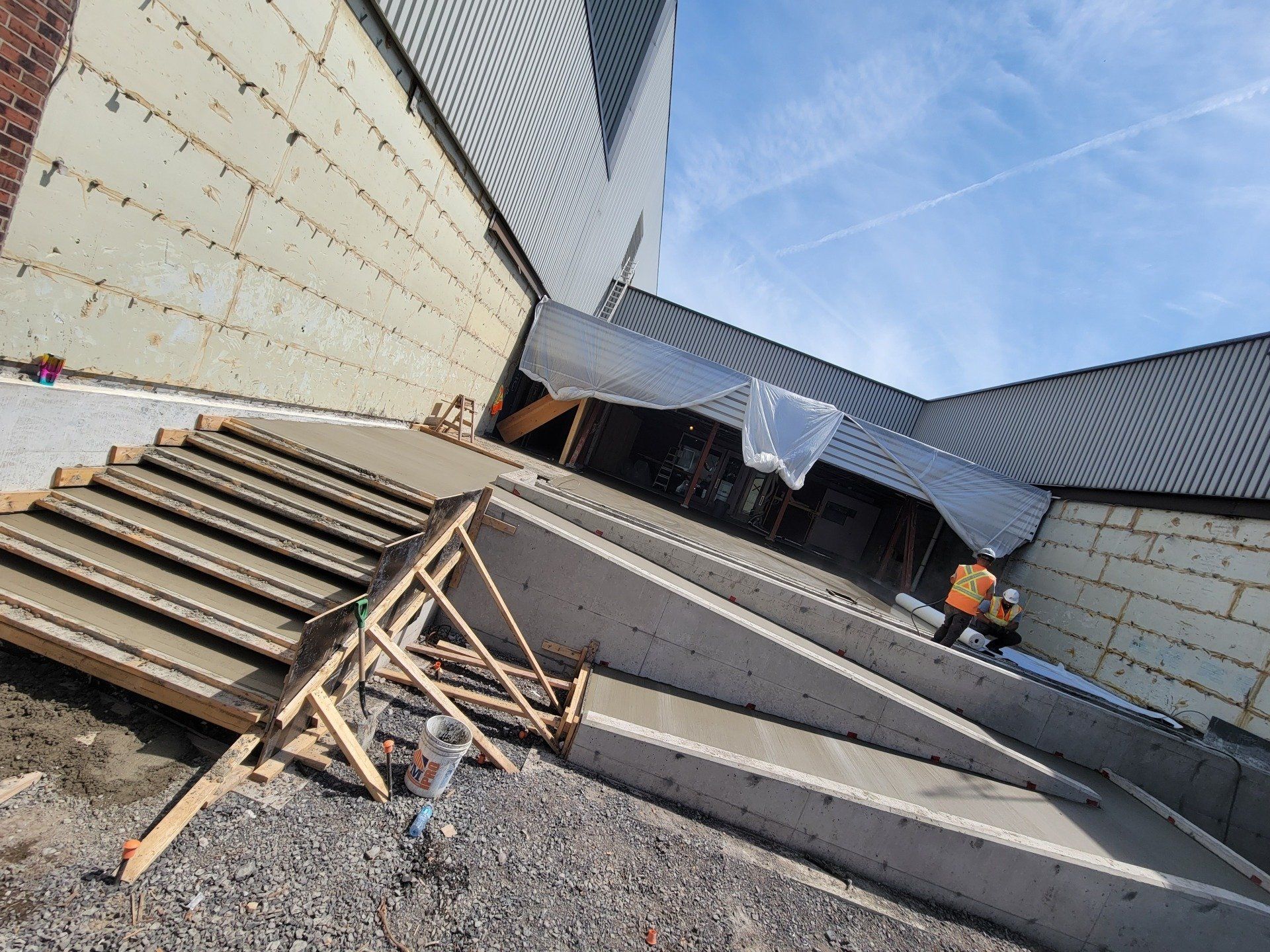 A concrete ramp is being built in front of a building