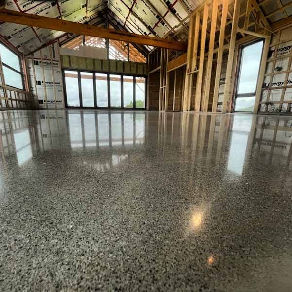 A large room with a shiny concrete floor and lots of windows.