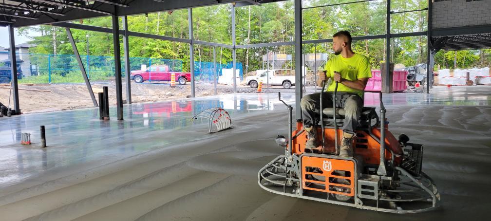 A man is riding a machine on a concrete floor.