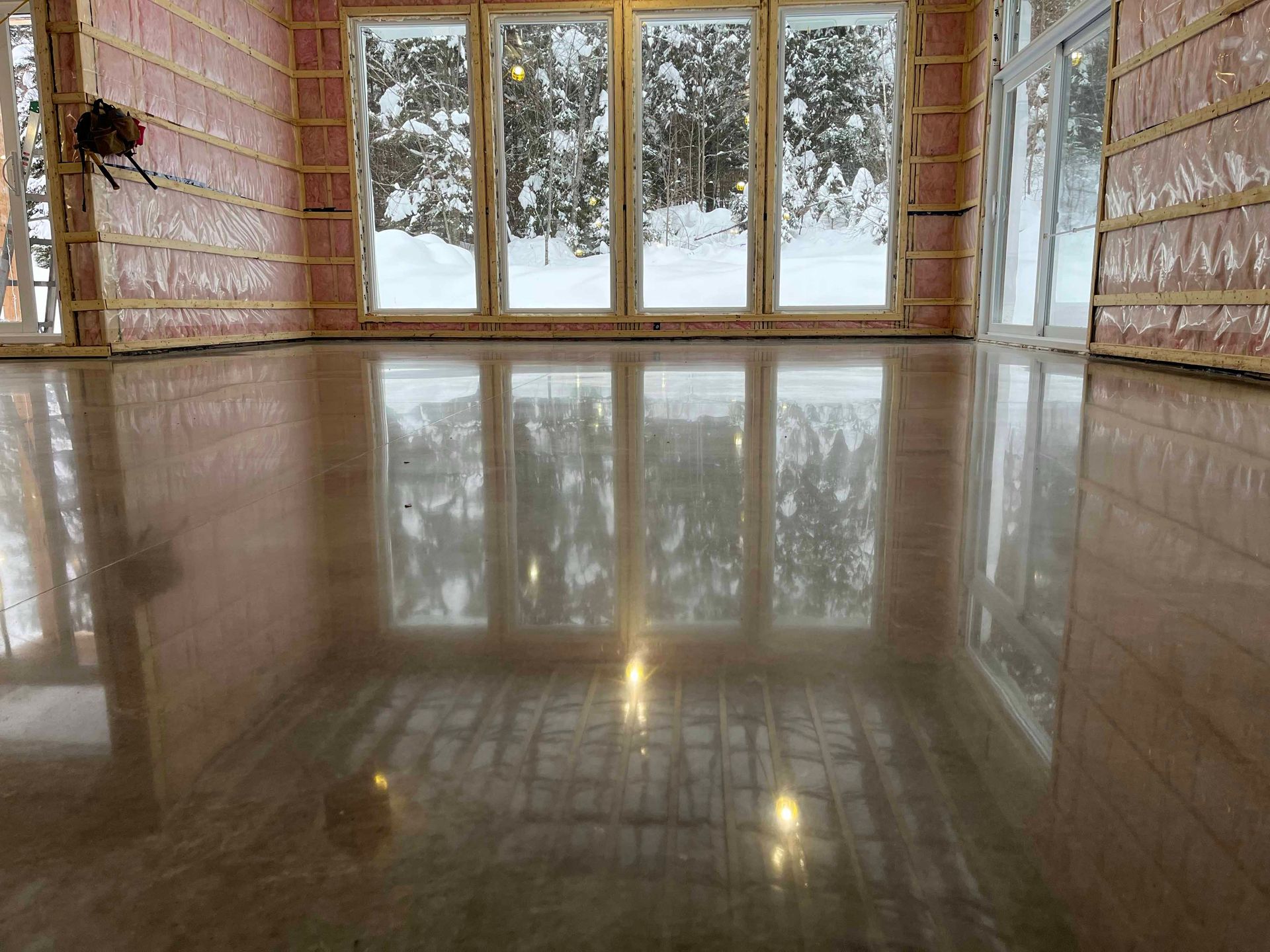 Une pièce avec beaucoup de fenêtres et un sol brillant.