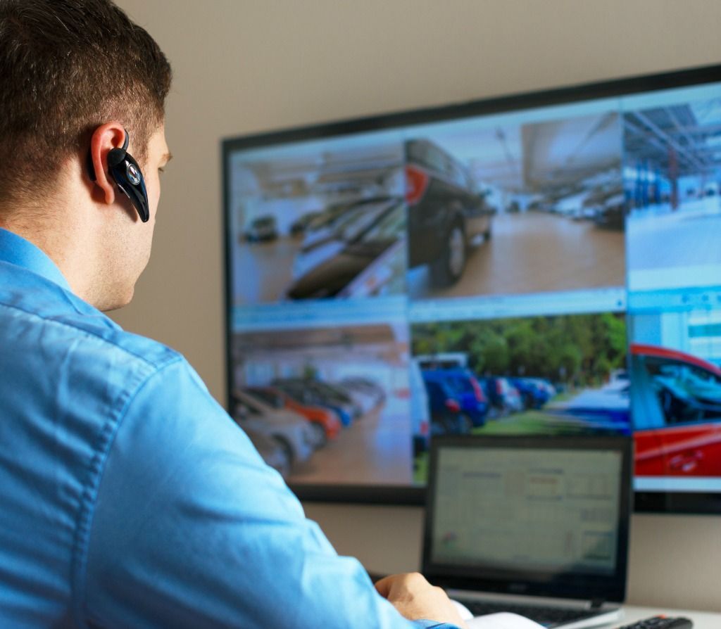 A man wearing a headset is sitting in front of a computer monitor.