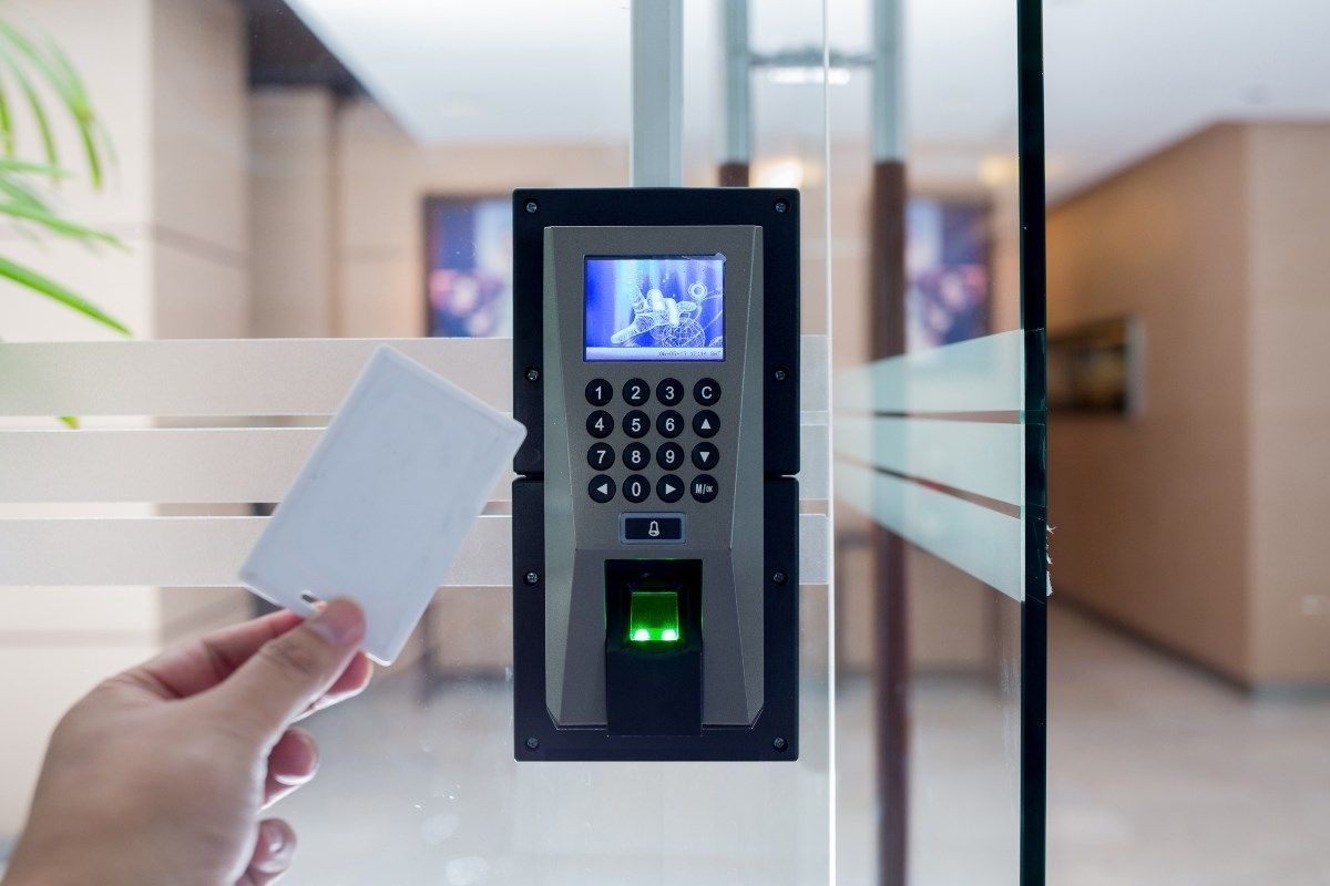 A person is holding a card in front of a fingerprint scanner.