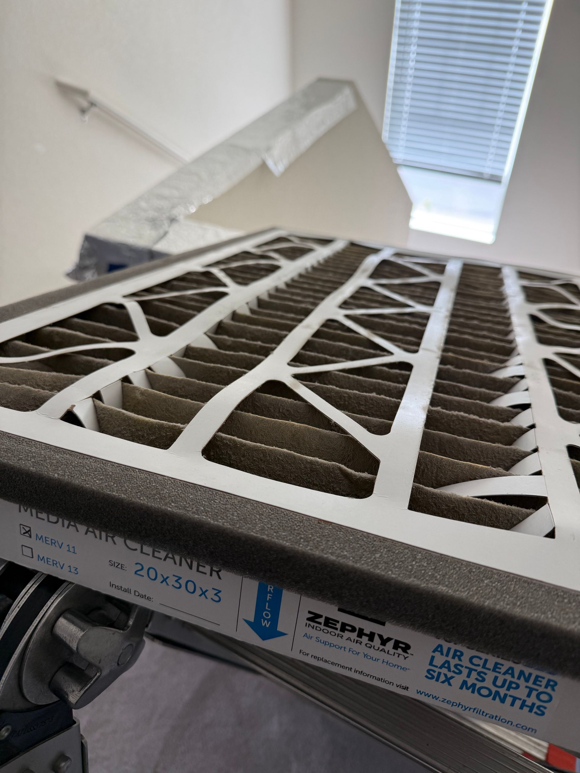 Pleated media air filter being inspected during a Sacramento area AC tune-up